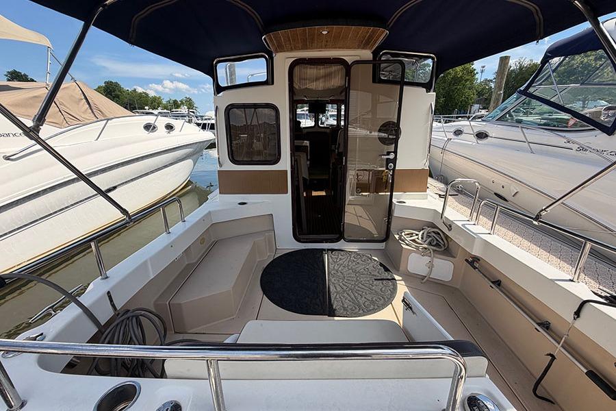 2016 Ranger Tugs R-27 boat interior with seating and canopy at marina.