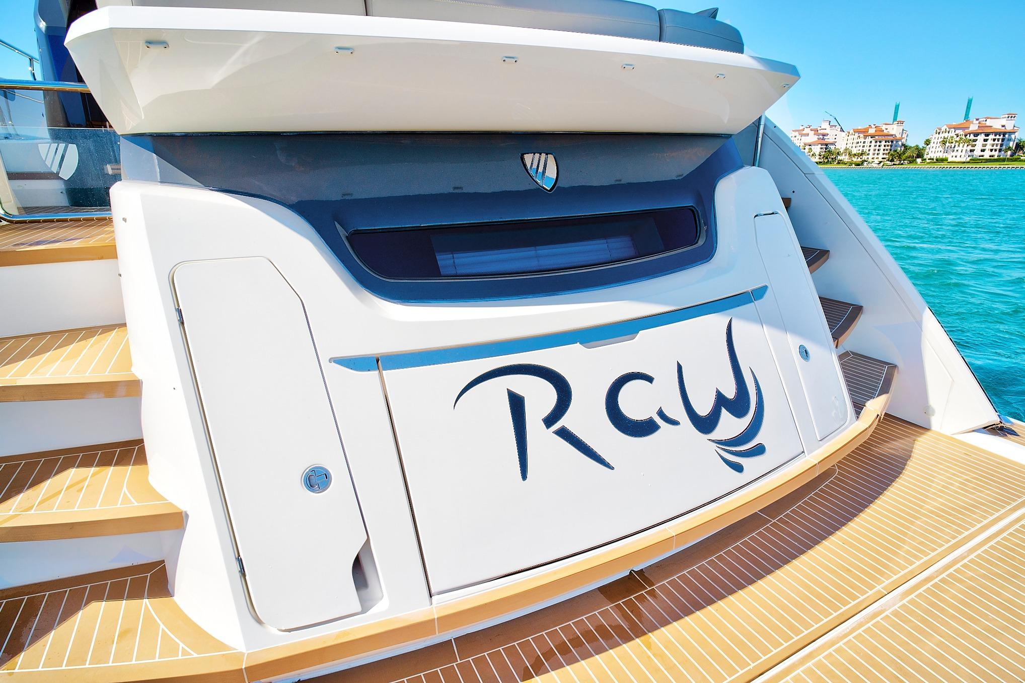2021 Fairline Squadron 68 yacht stern with custom lettering, docked by turquoise water.