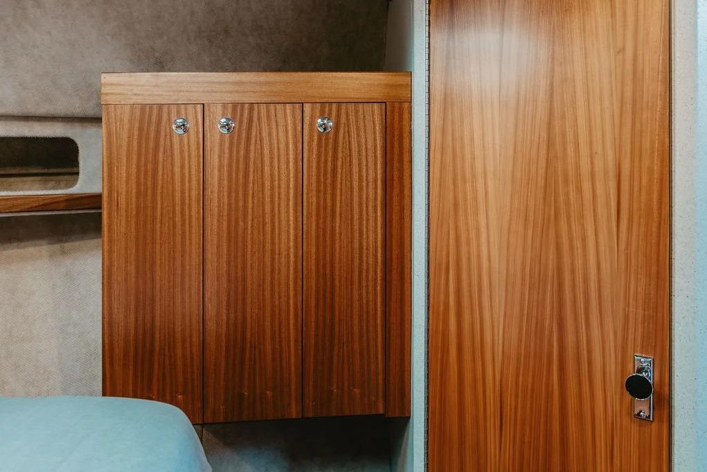 Interior of 2026 KingFisher 38 GFX boat with wooden cabinetry and door.