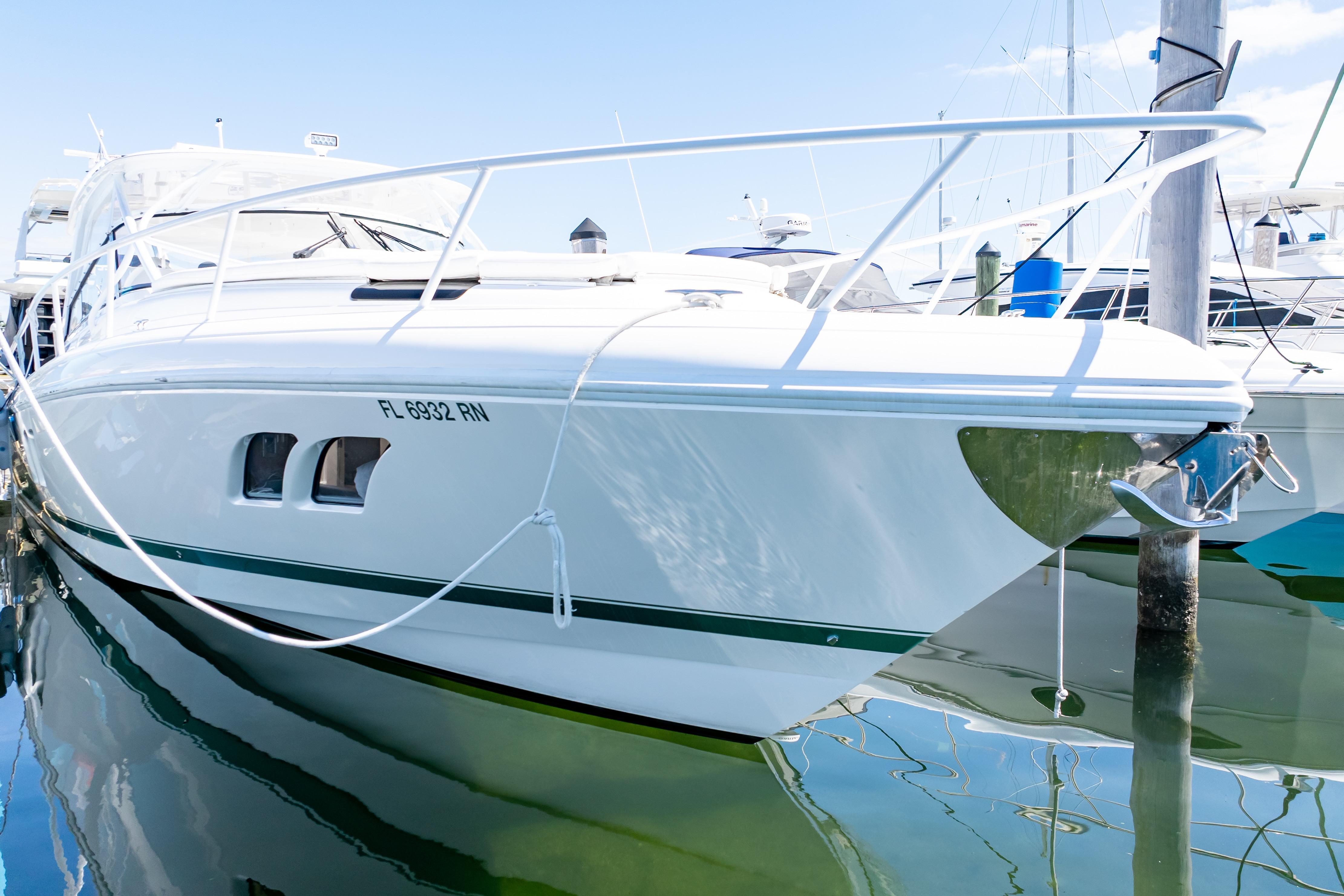2018 Intrepid 475 Sport Yacht docked in marina, reflecting on calm water.