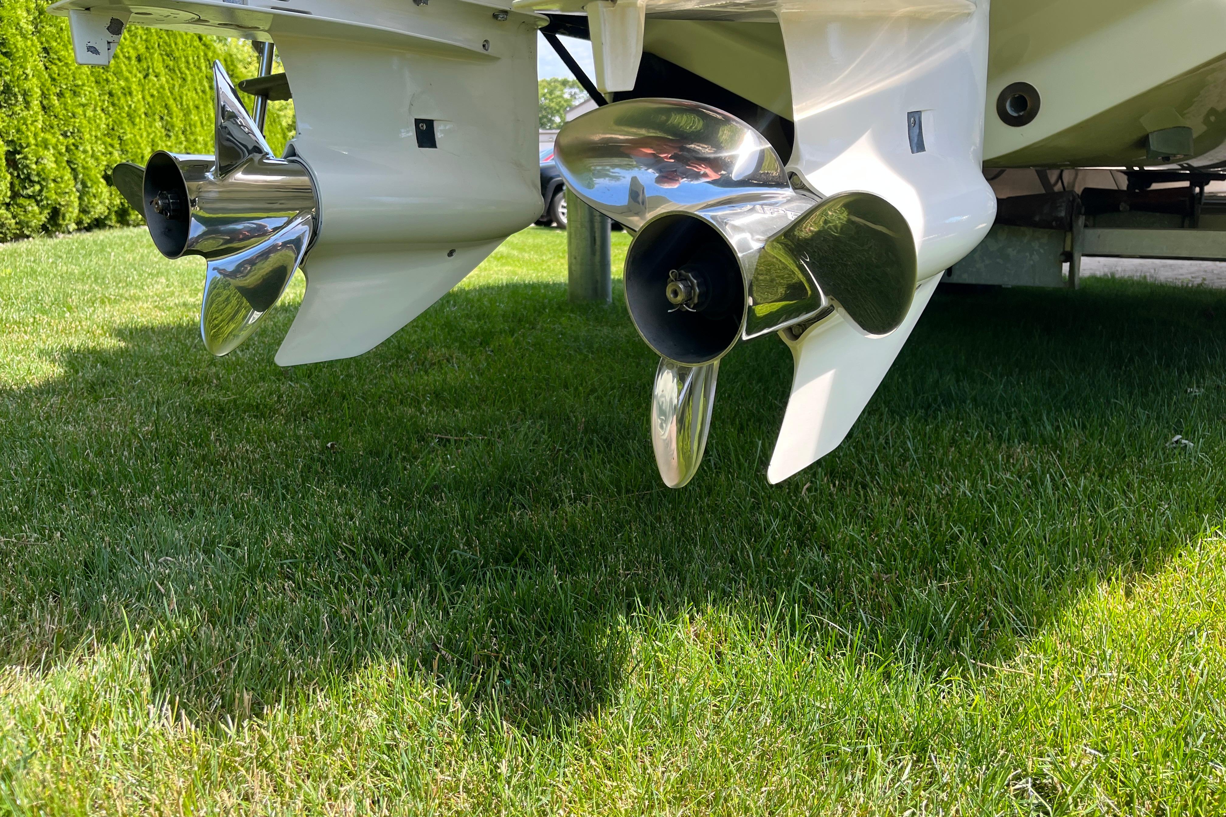 Propellers of a 1994 Intrepid 30 Open Cuddy boat on grass.
