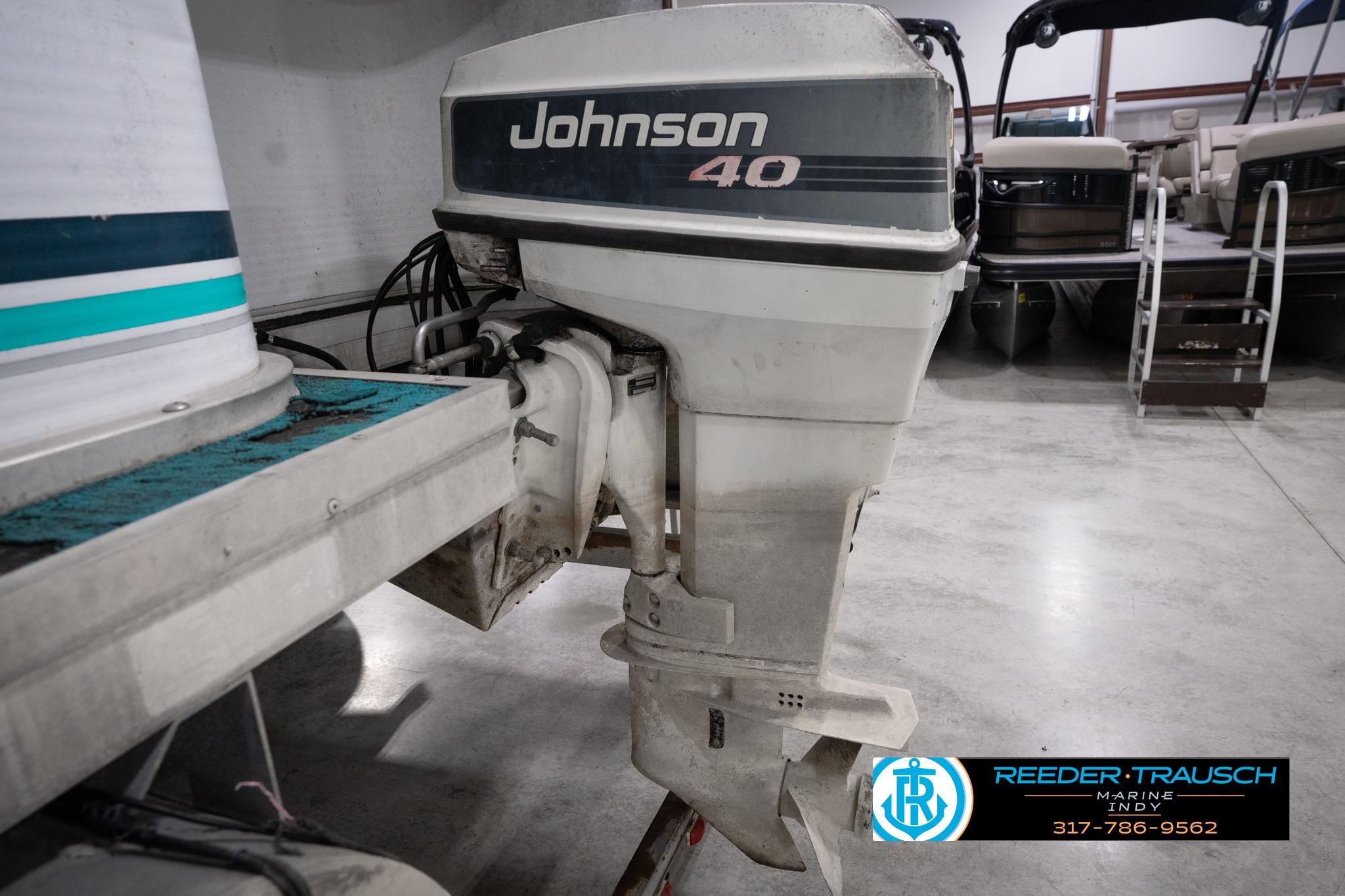 1992 Godfrey Sweetwater boat with Johnson 40 outboard motor in a showroom.