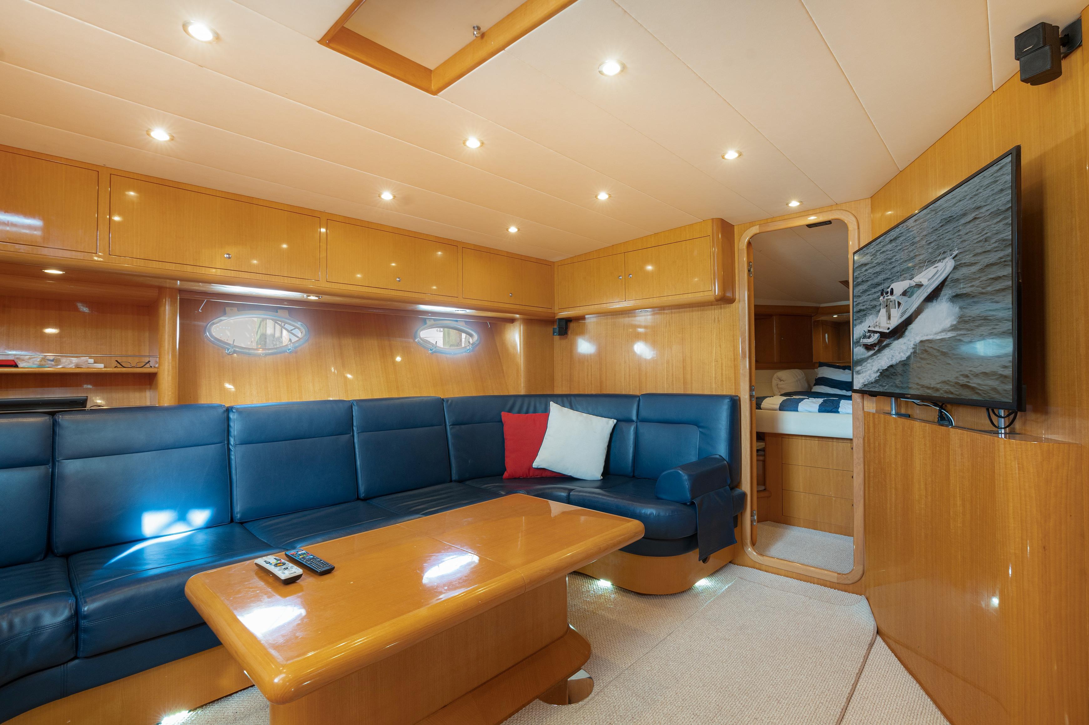Luxurious interior of 2001 Uniesse 48 Open yacht with blue seating and wood finishes.