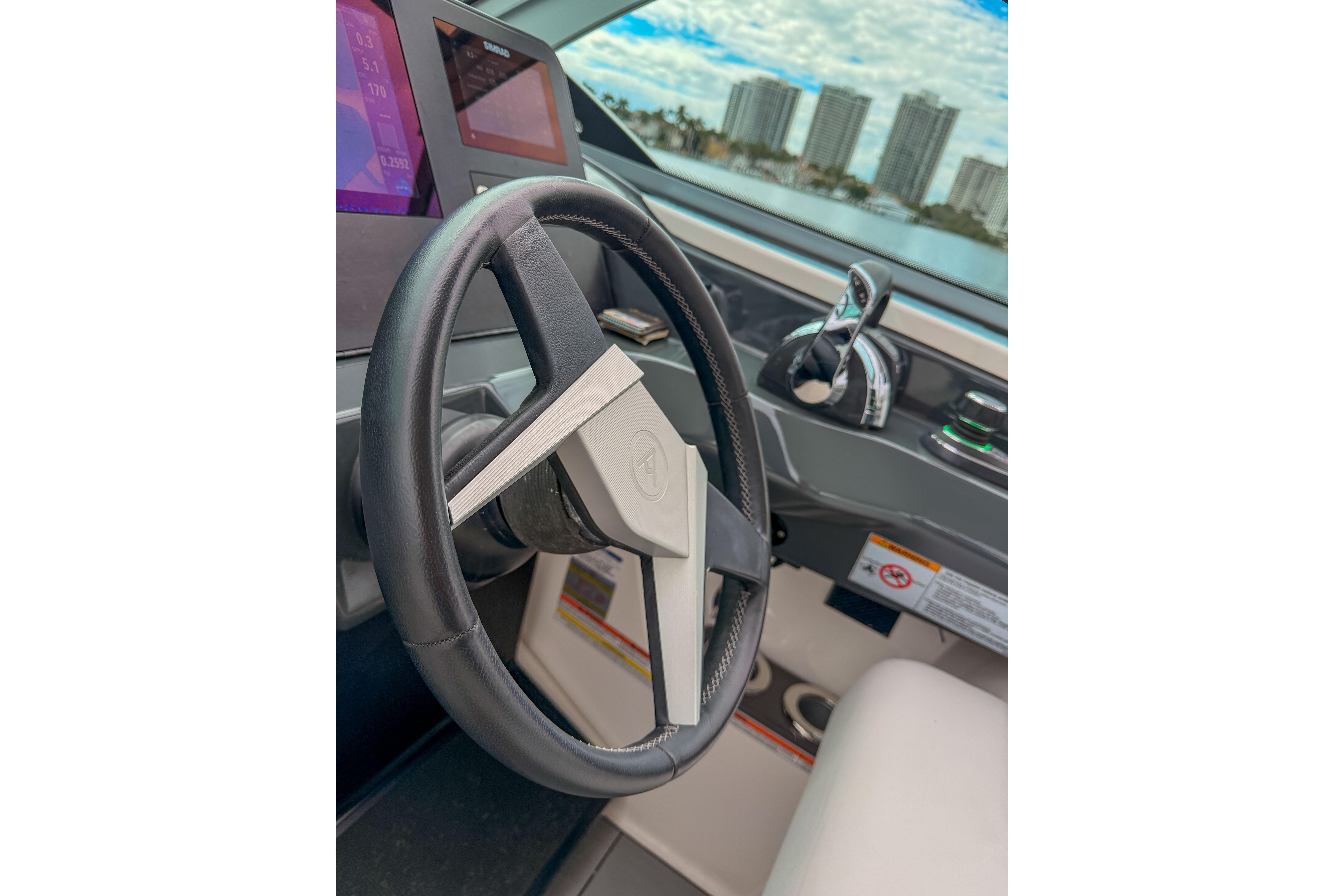 Steering wheel of 2022 Aviara AV32 OB boat with modern dashboard controls.
