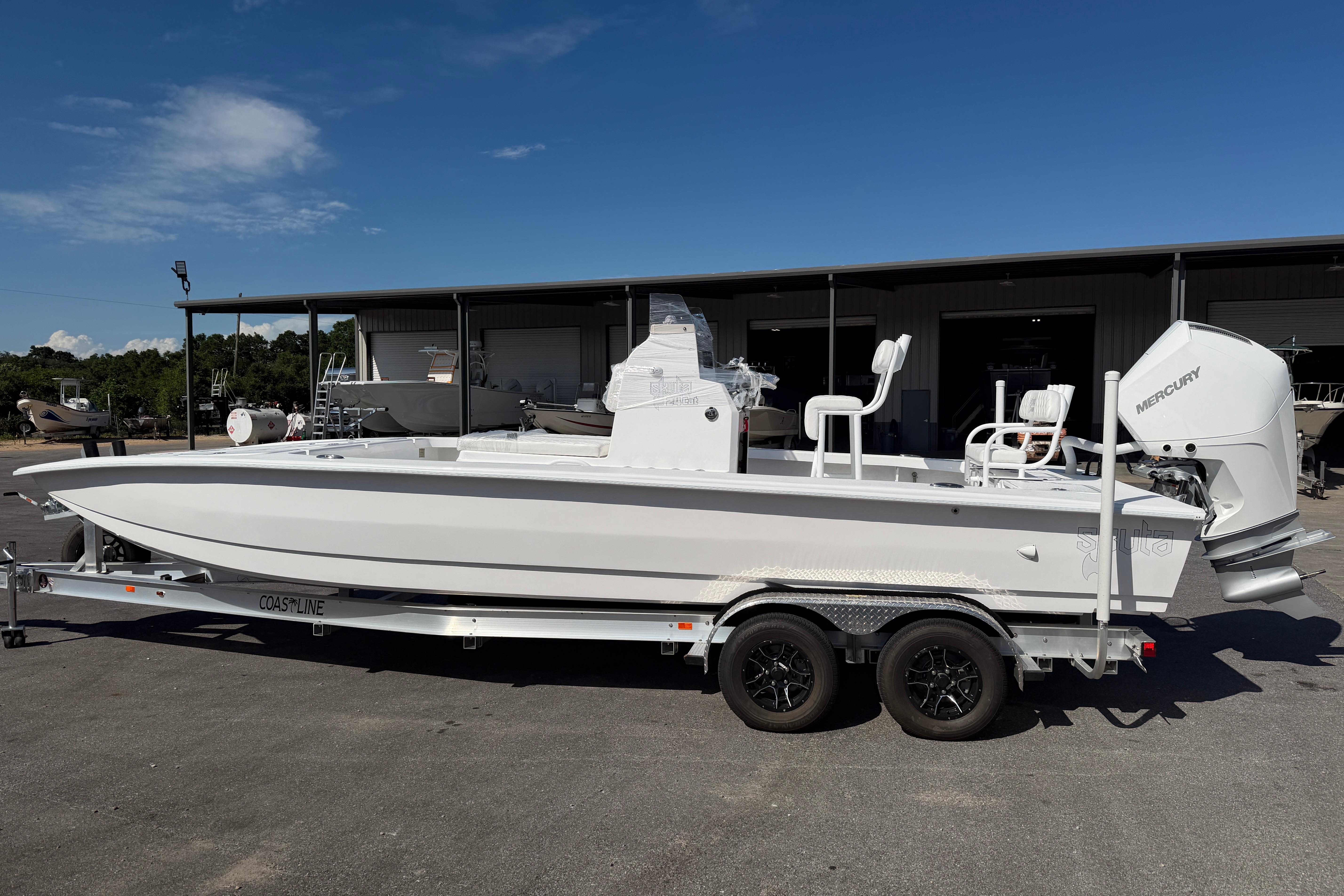 2026 Skuta 24 Cat boat on trailer, featuring Mercury outboard motor, parked outdoors.