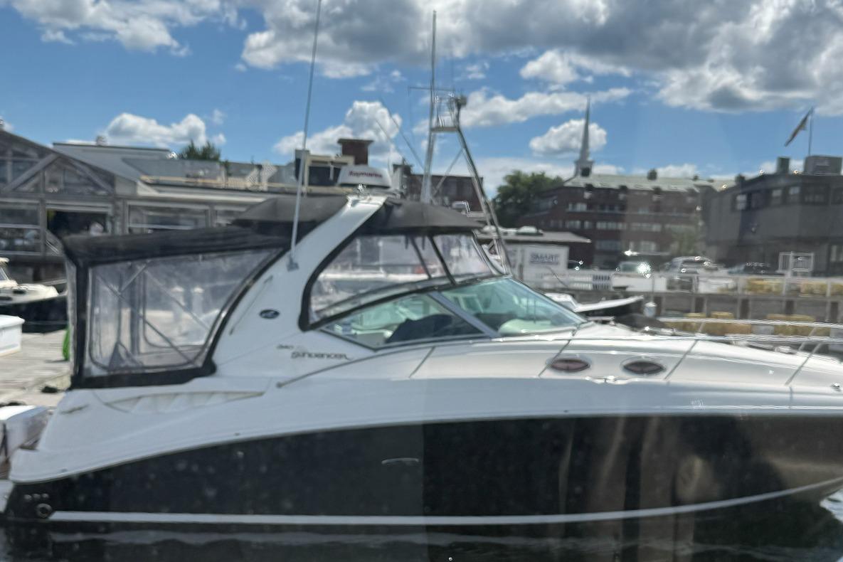 2006 Sea Ray 300 Sundancer docked at marina under partly cloudy sky.