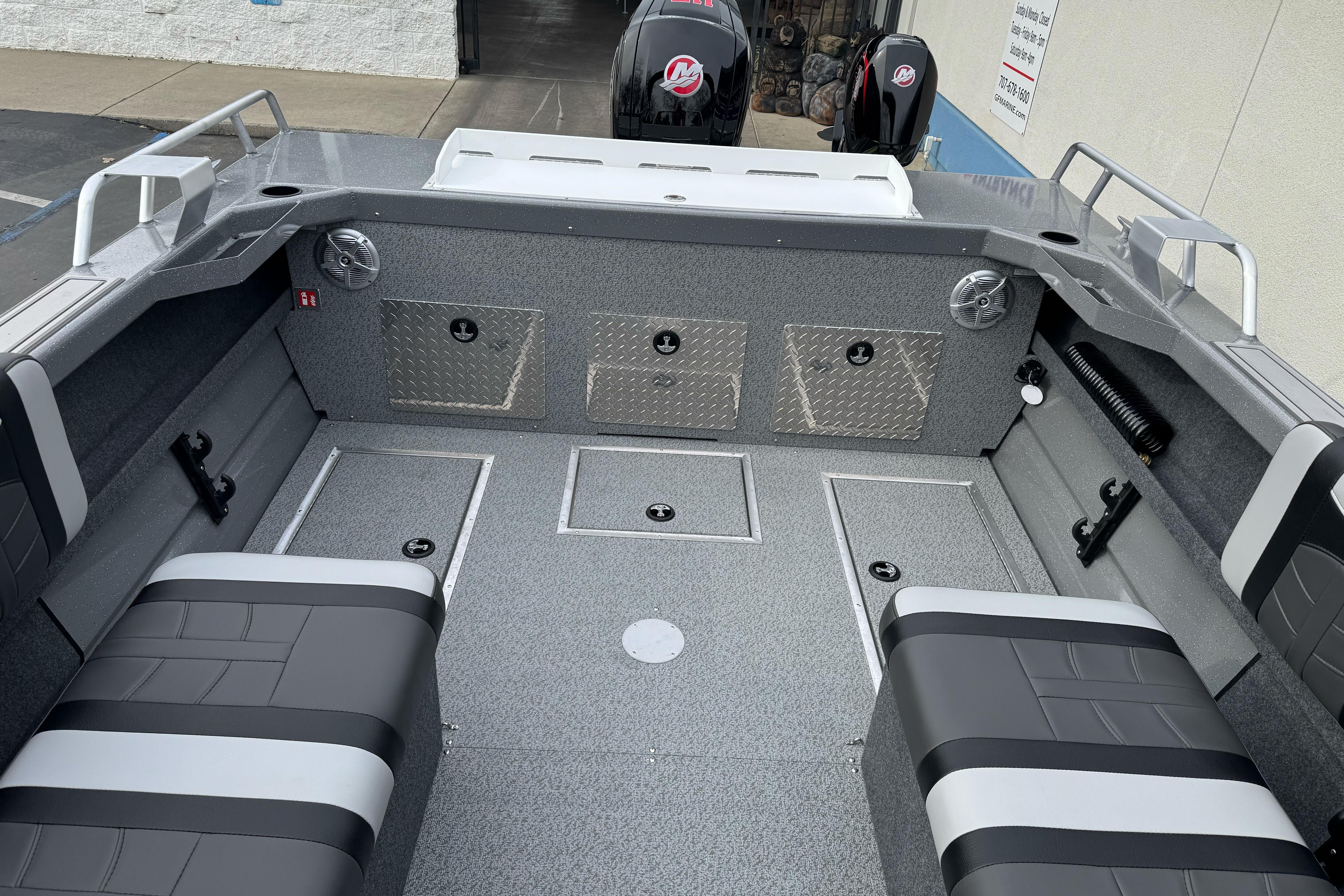 2026 Lund 185 Heavy Gauge boat interior with gray seating and storage compartments.