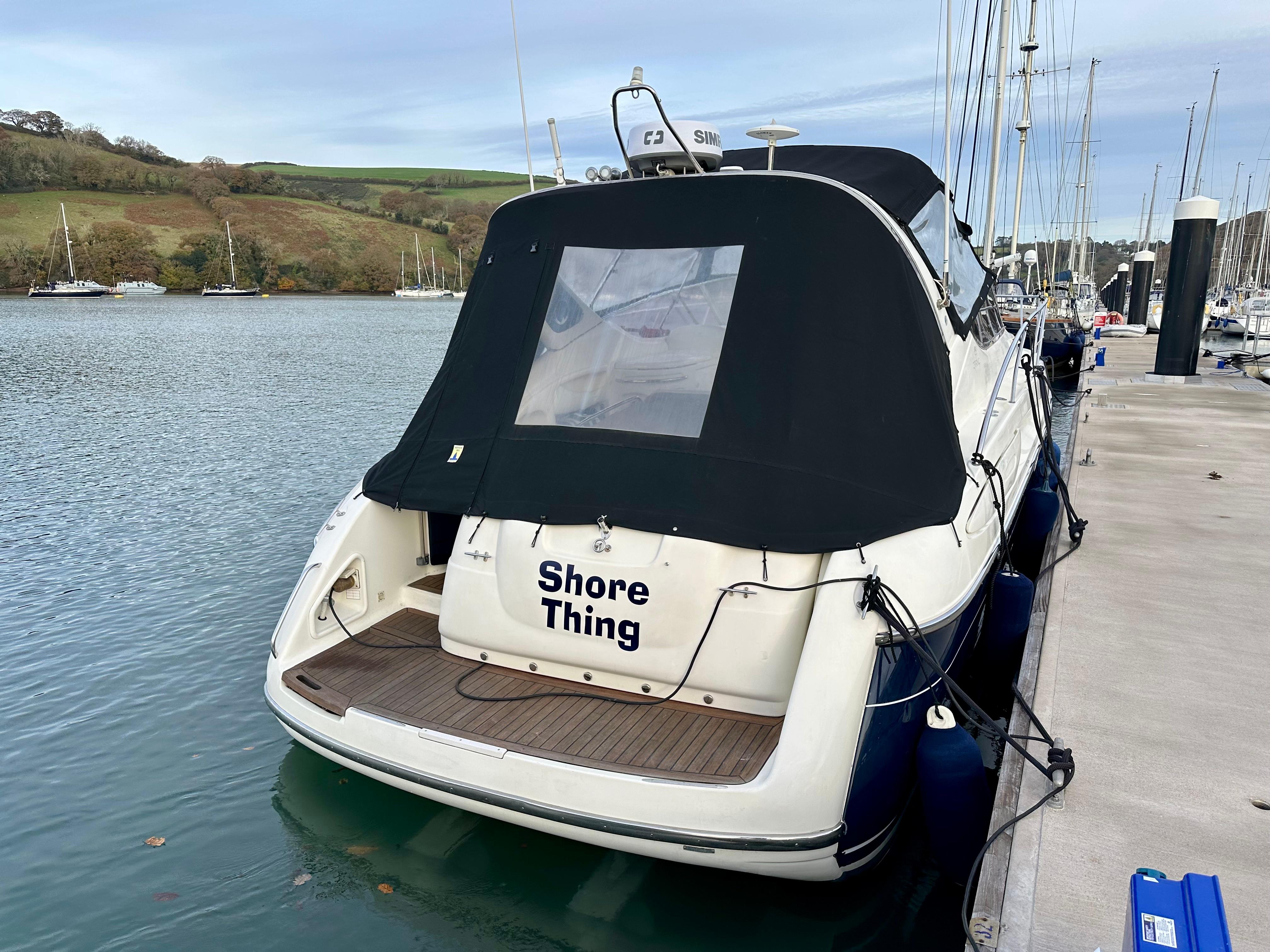 1999 Cranchi Endurance 39 yacht docked, featuring a black cover and "Shore Thing" text.