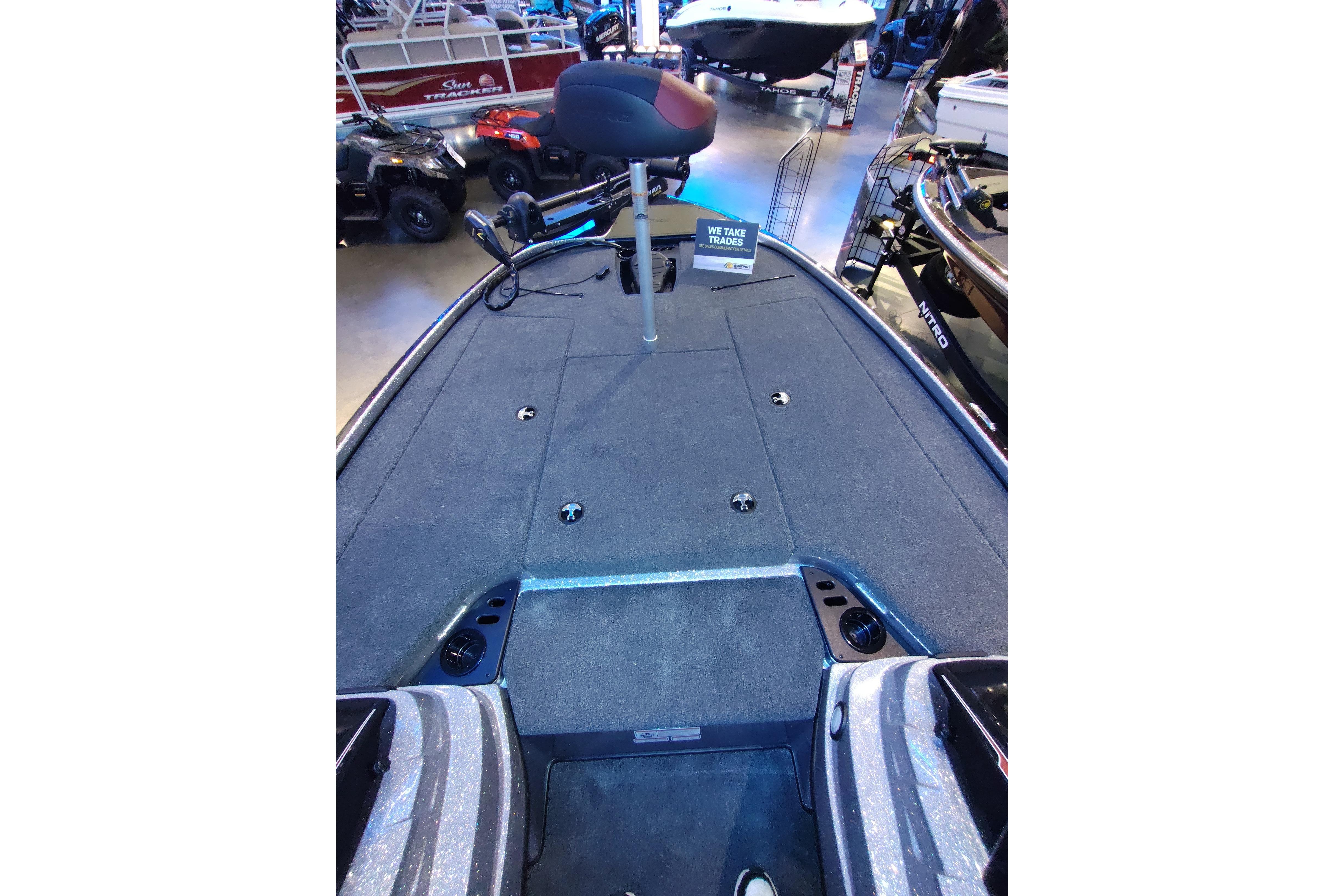 2026 Nitro Z18 boat interior with carpeted deck and fishing seat at a showroom.