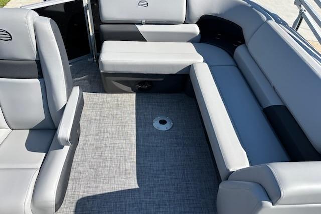 2026 Sun Tracker Party Barge 20 DLX interior with gray seating and carpeted floor.