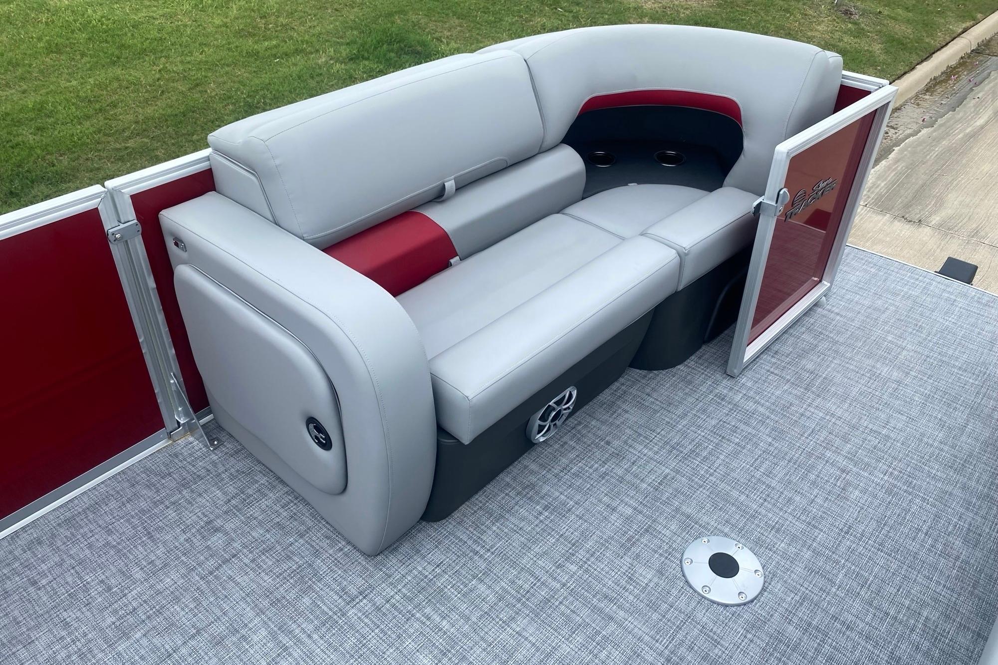 2026 Sun Tracker Party Barge 22 RF DLX with gray and red seating on deck.