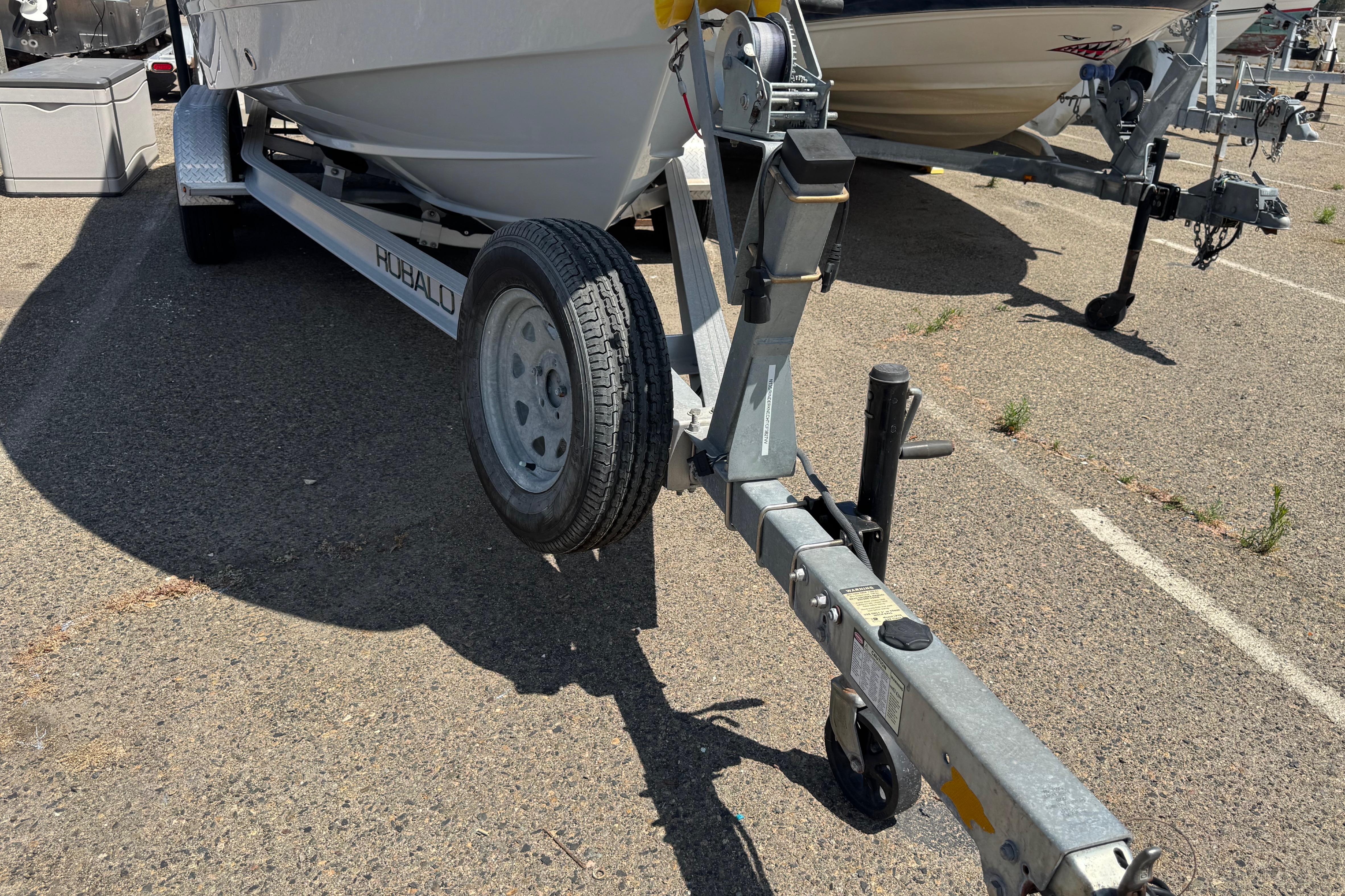 2022 Robalo R230 Center Console boat on trailer in parking lot.