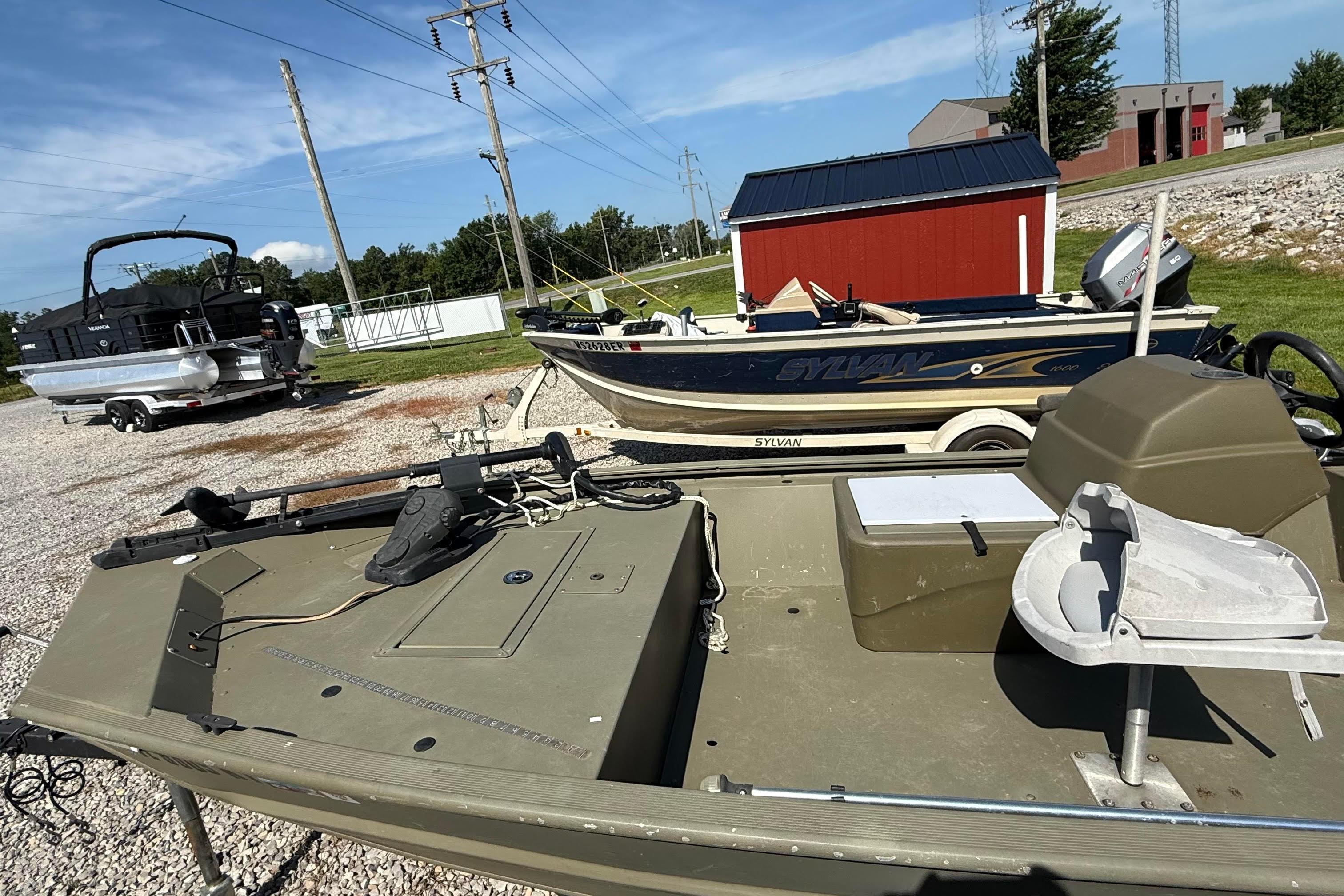 2019 Tracker Grizzly 1648 SC boat in outdoor storage, alongside other boats.
