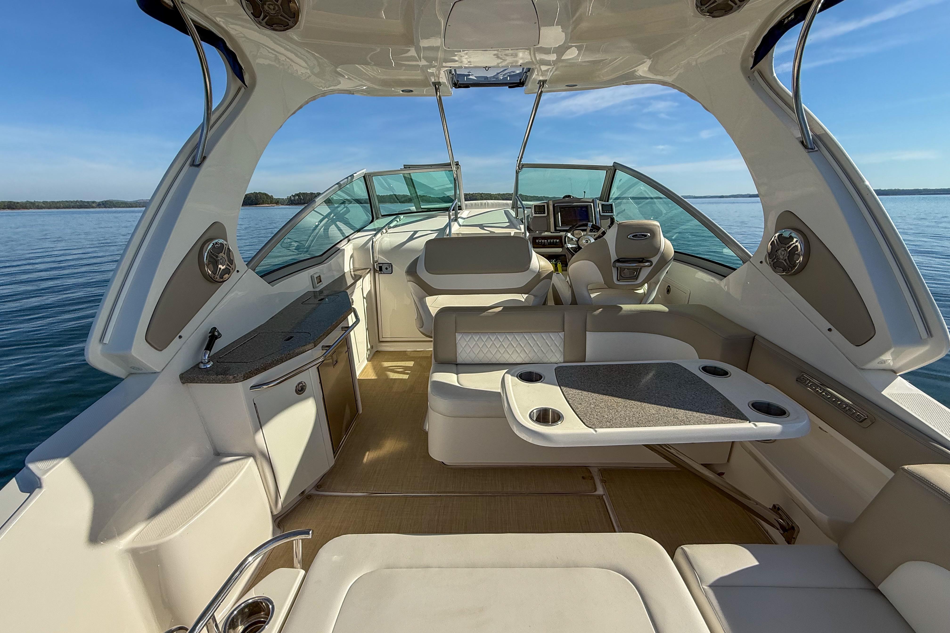 Interior view of 2014 Chaparral 310 Signature boat, featuring seating and helm.
