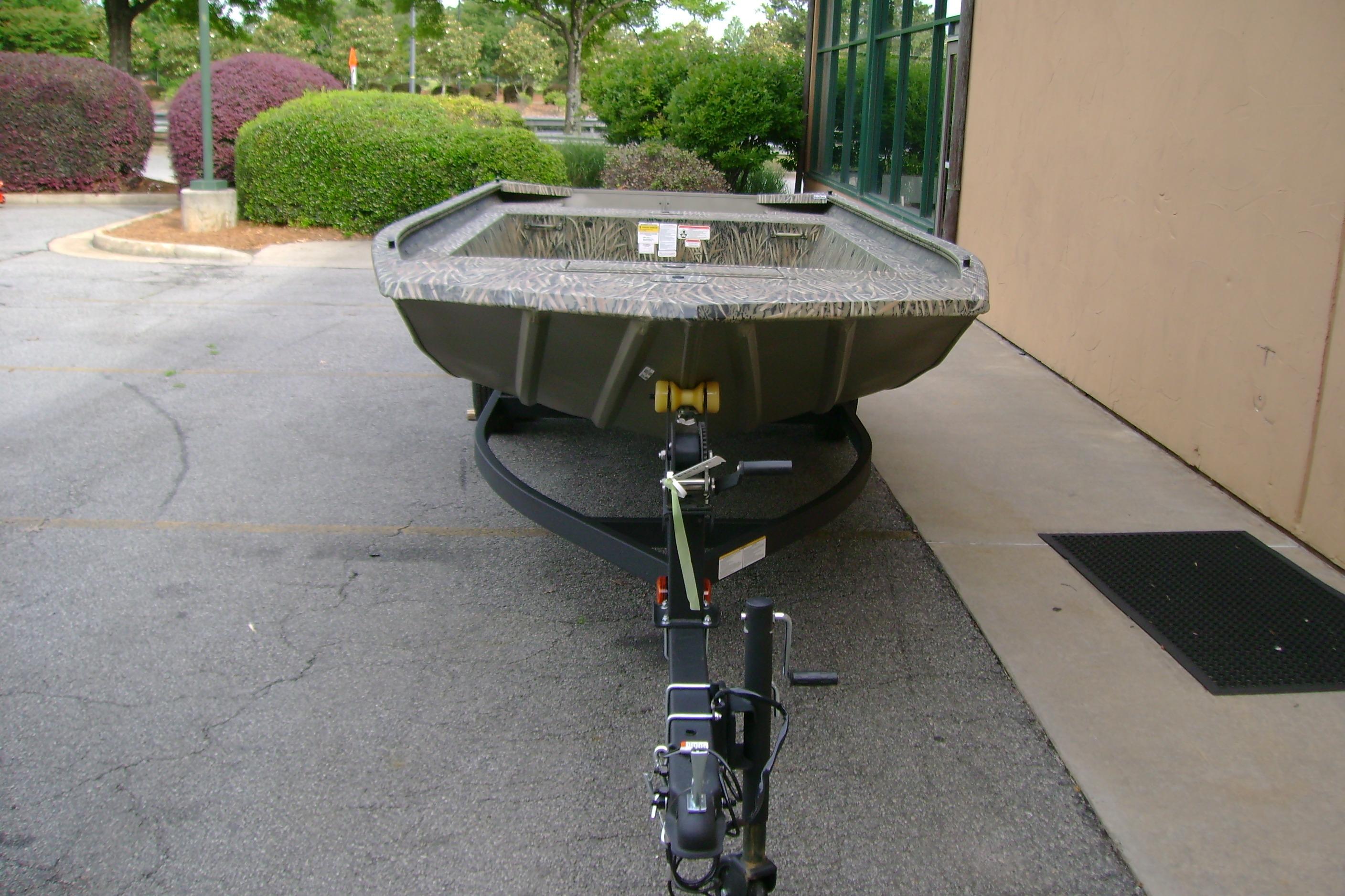 2026 Tracker Grizzly 1754 Utility boat on trailer in parking lot.
