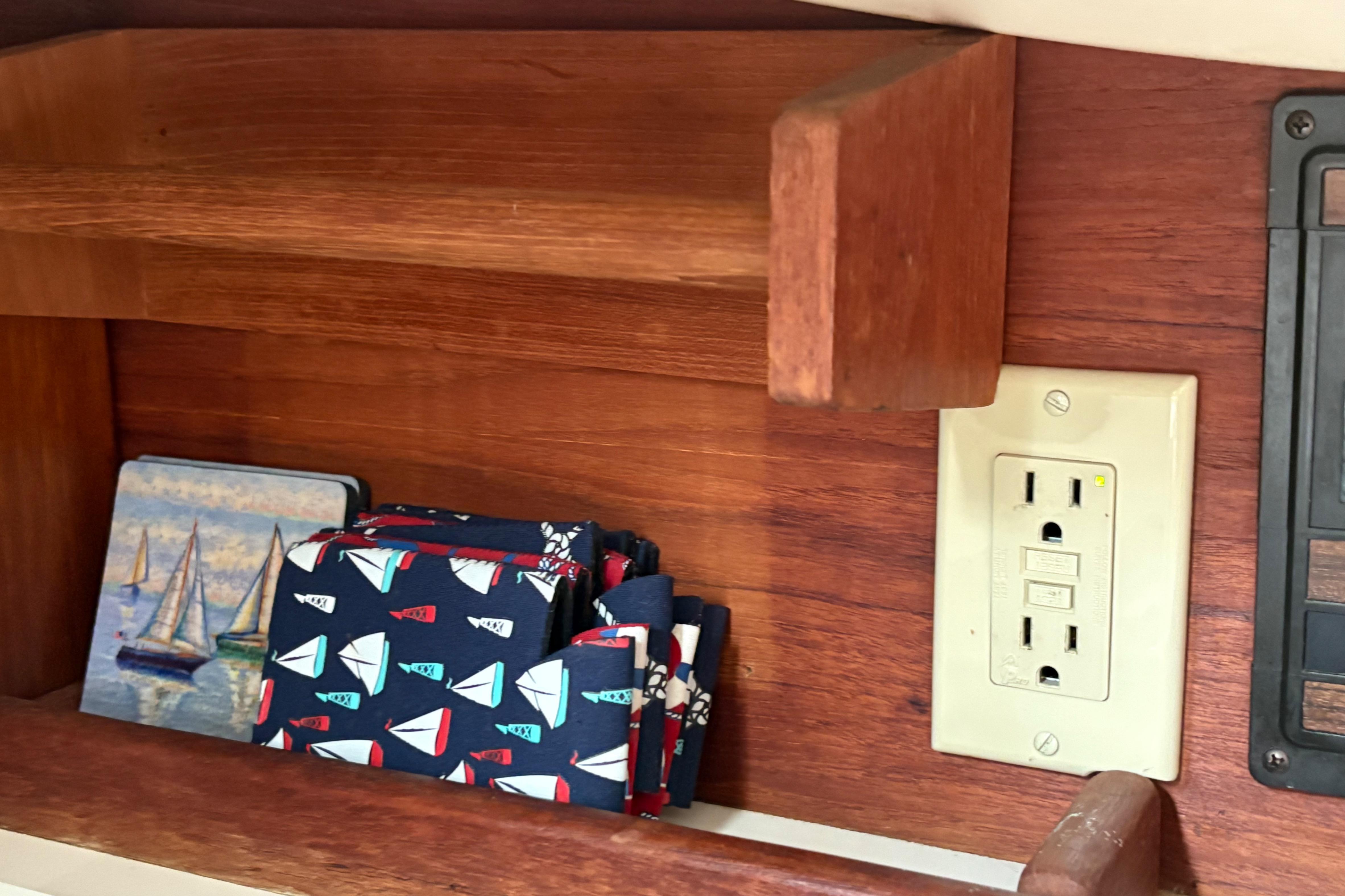 Wooden shelf with nautical-themed coasters and napkins, electrical outlet, Sabre 31, 1981.