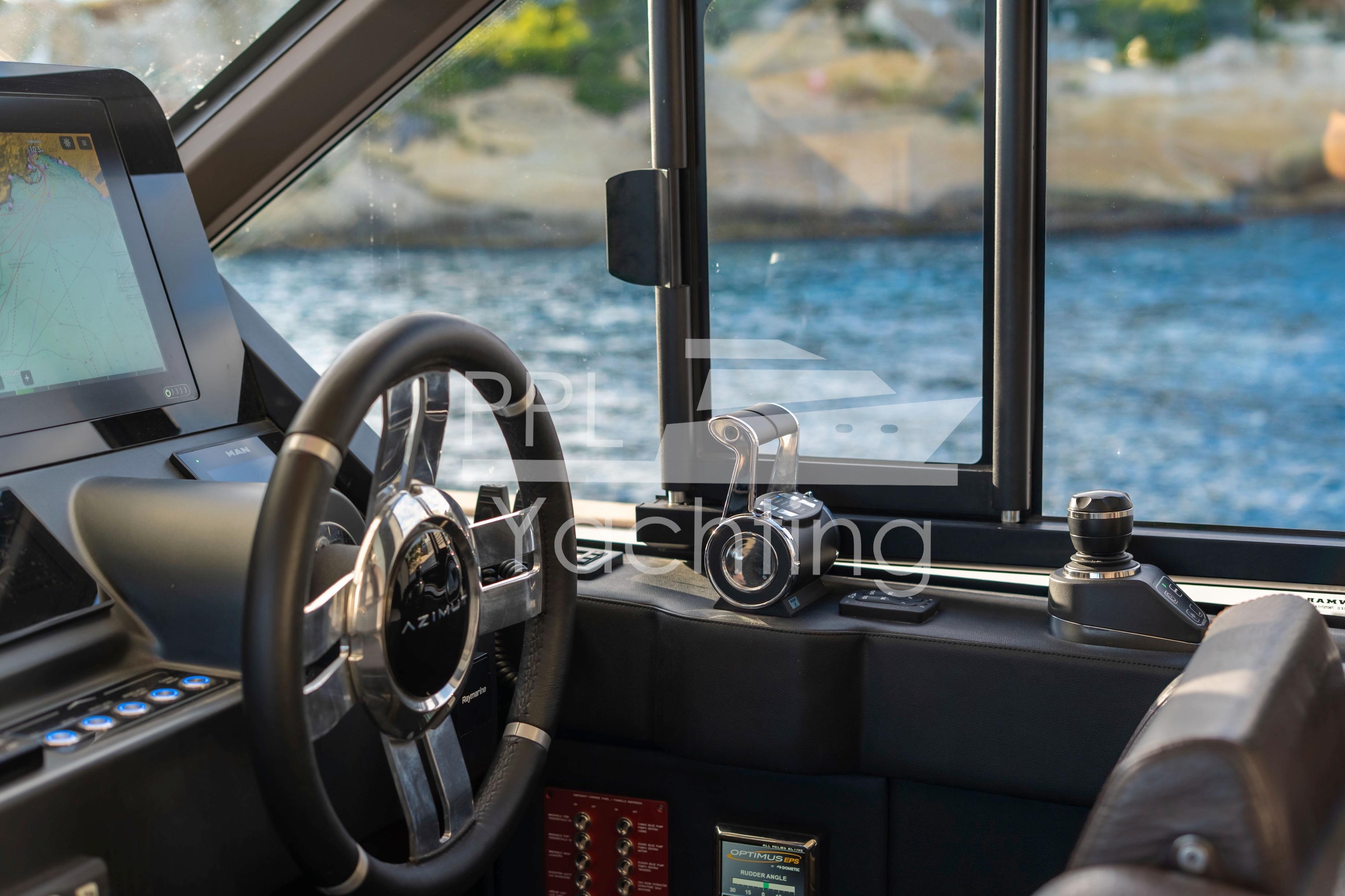 Interior helm of 2021 Azimut Magellano 66 yacht with steering wheel and navigation controls.