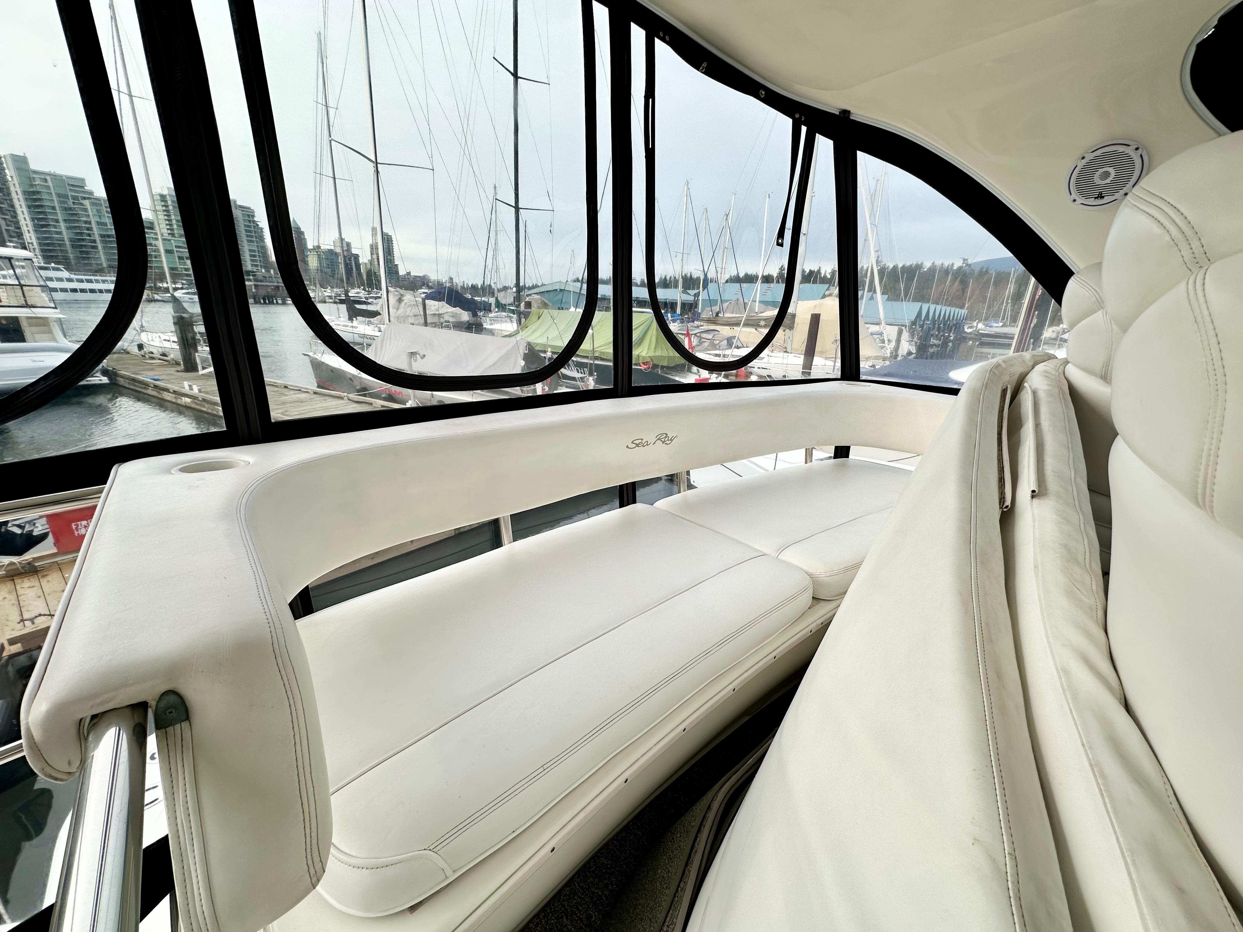 2002 Sea Ray 560 Sedan Bridge interior with white seating and marina view.