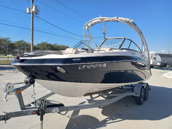 2010 Yamaha Boats 242 Limited on trailer, sleek design, black and white exterior.