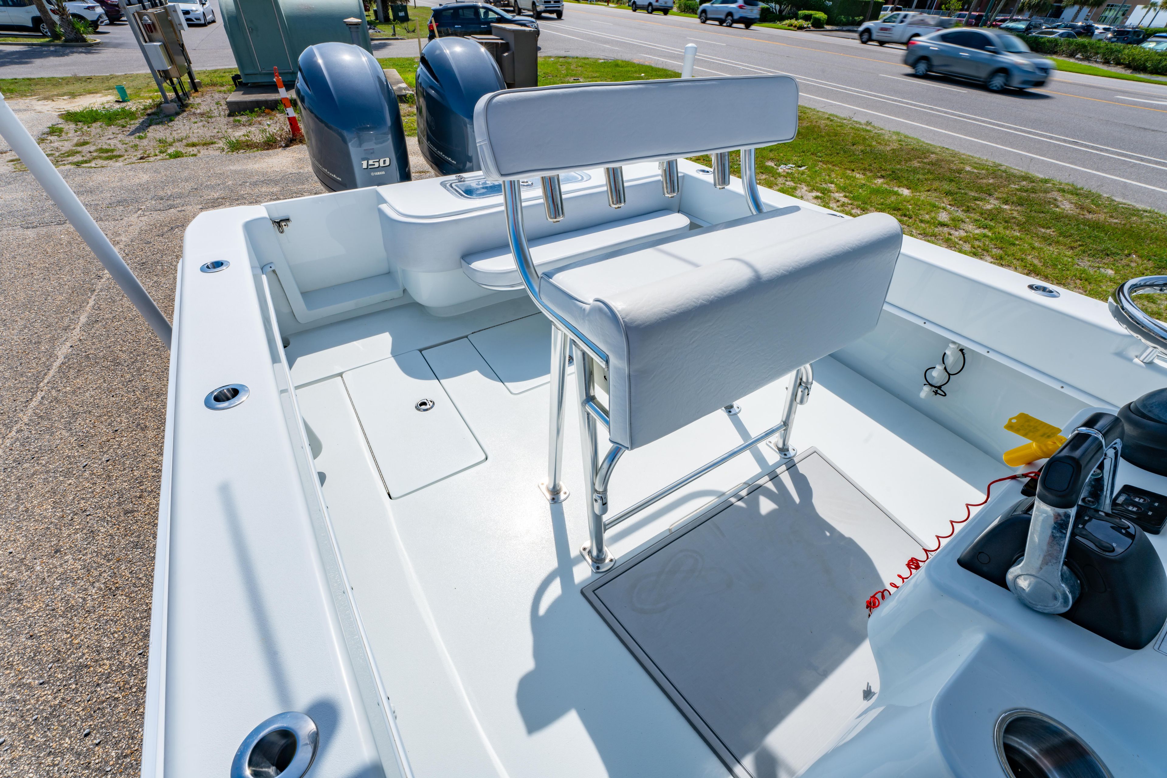 2022 Contender 25T boat interior with dual engines and seating, parked near a road.