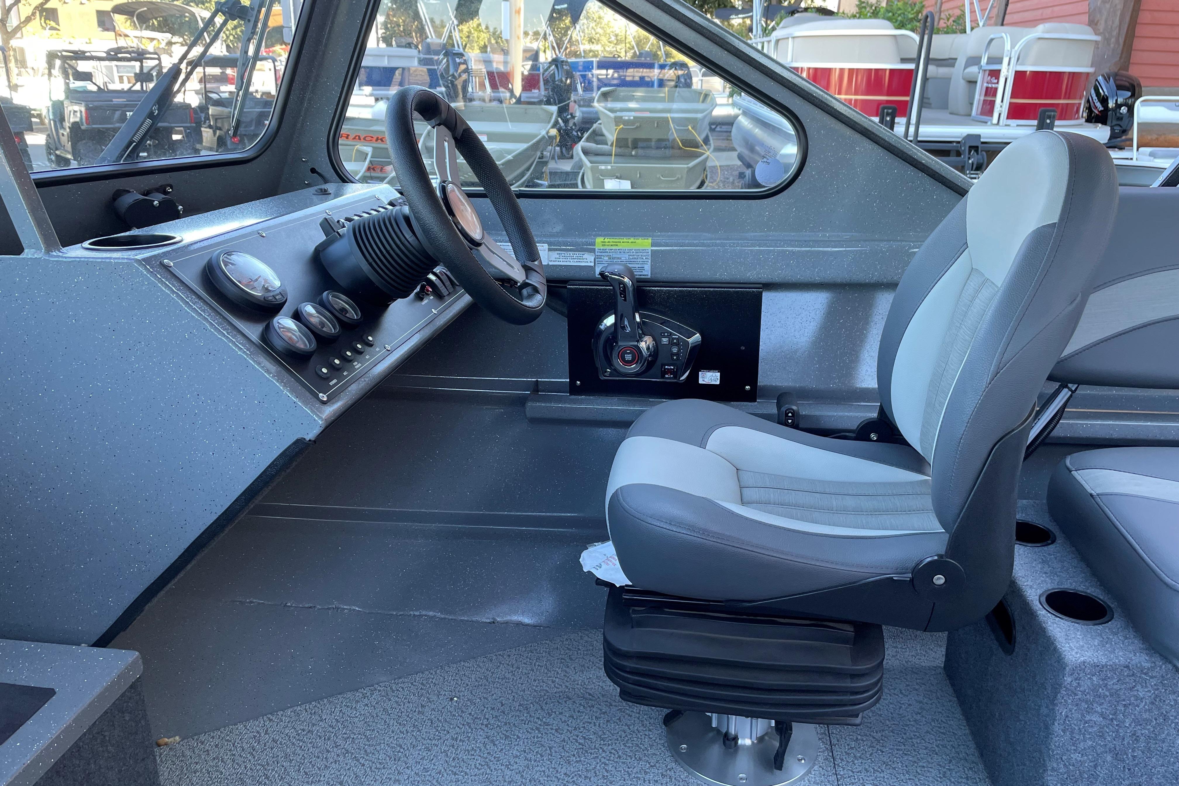 2025 Spartan 200 Astoria boat interior with steering wheel and captain's seat.