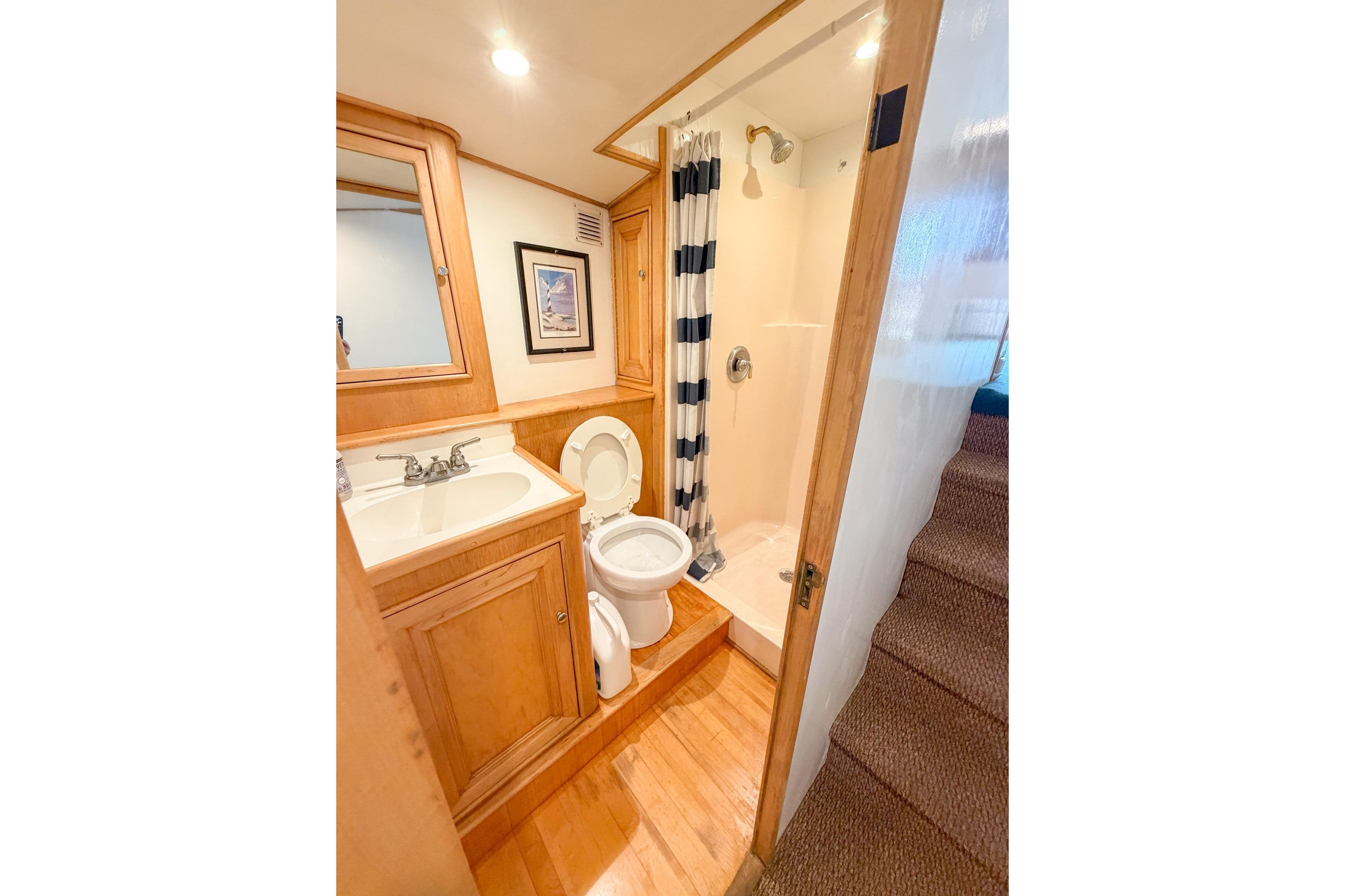 Bathroom interior of 1998 Blackwell Custom Carolina Sportfish boat, featuring shower and wooden cabinetry.