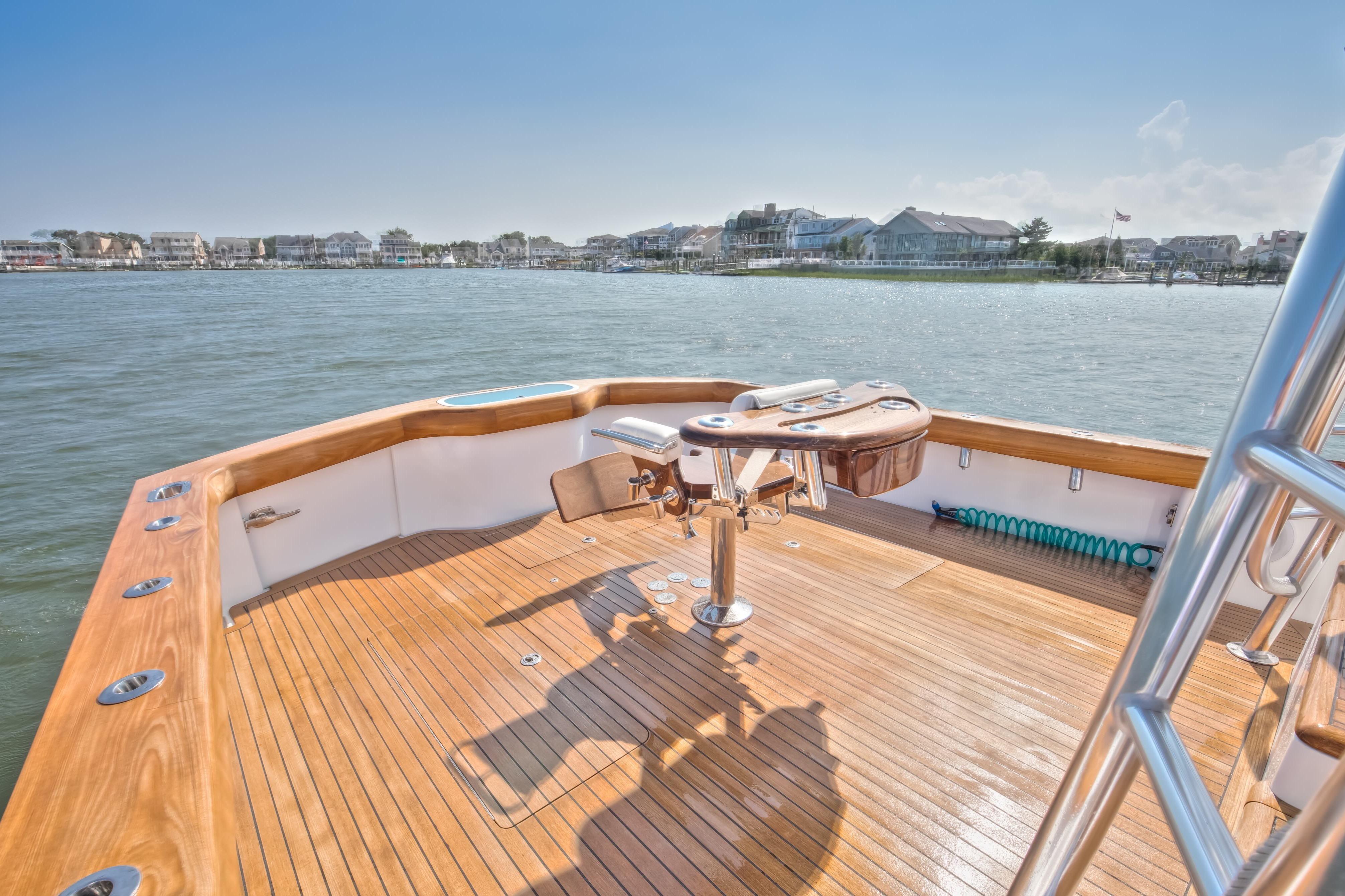 2026 Release Boatworks 46 Walkaround, featuring a spacious wooden deck with scenic waterfront views.