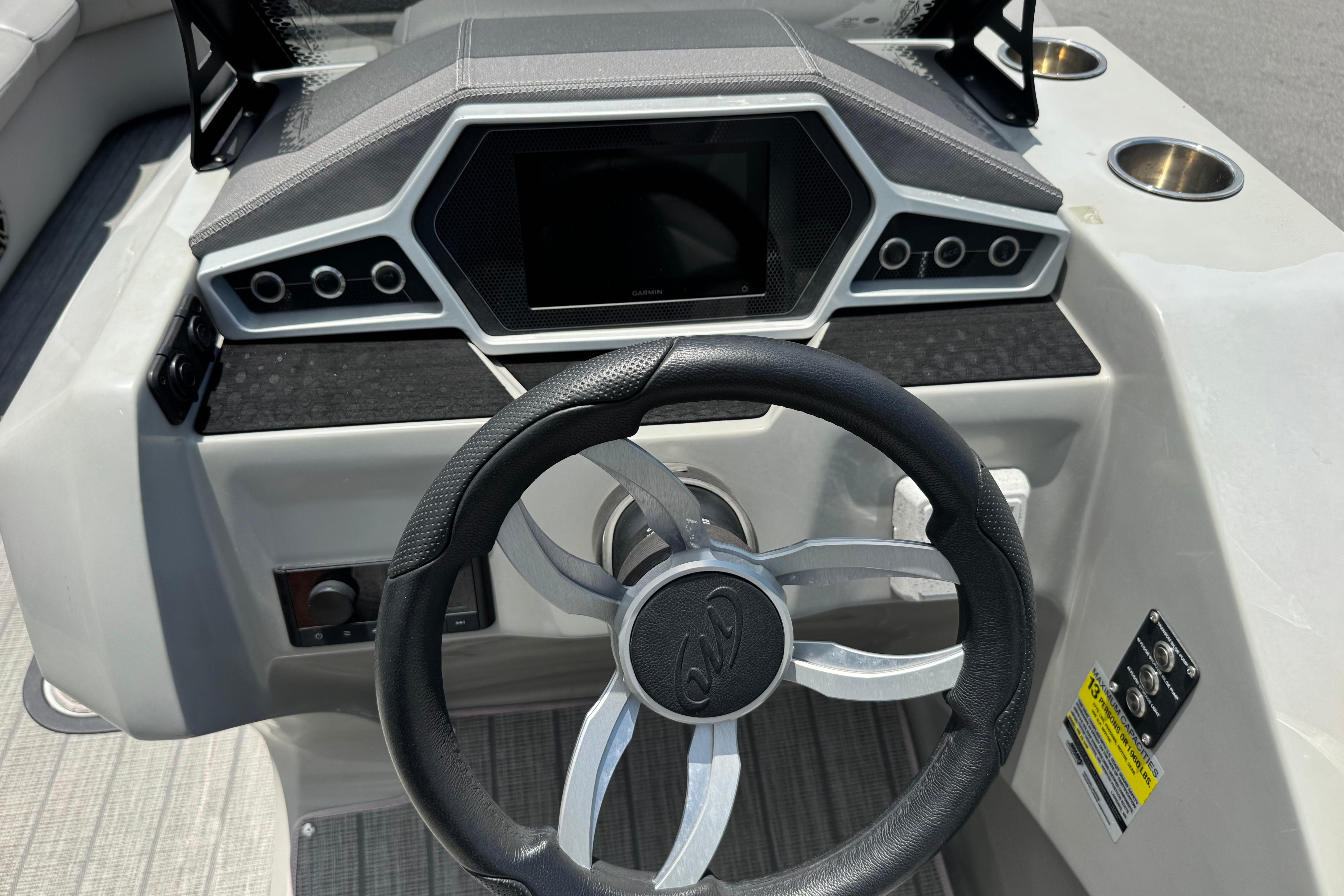 Steering console of 2022 Manitou 25 Encore boat with modern controls and display.