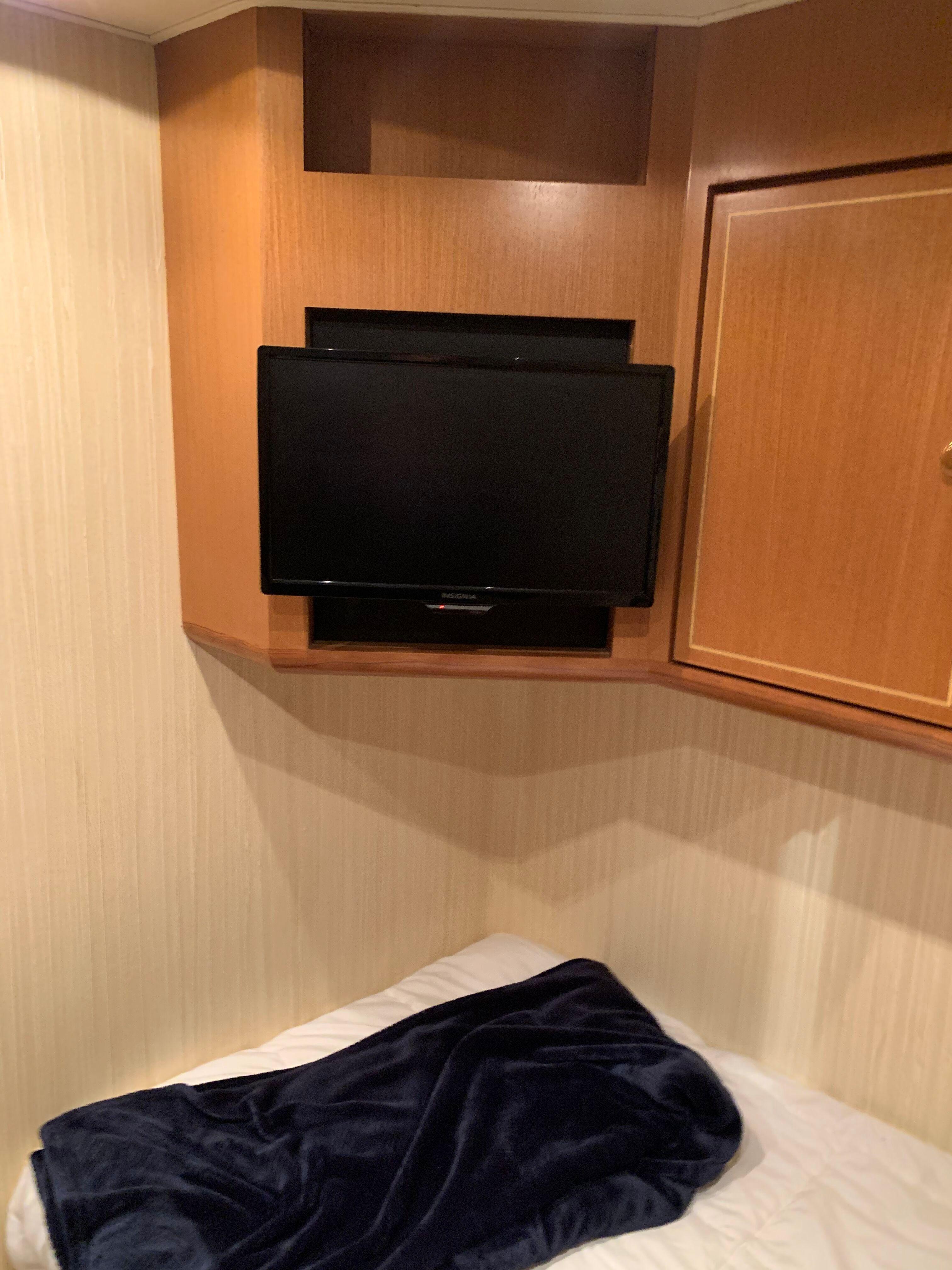 2004 Ocean Yachts 57 Odyssey cabin with TV and cozy bedding.