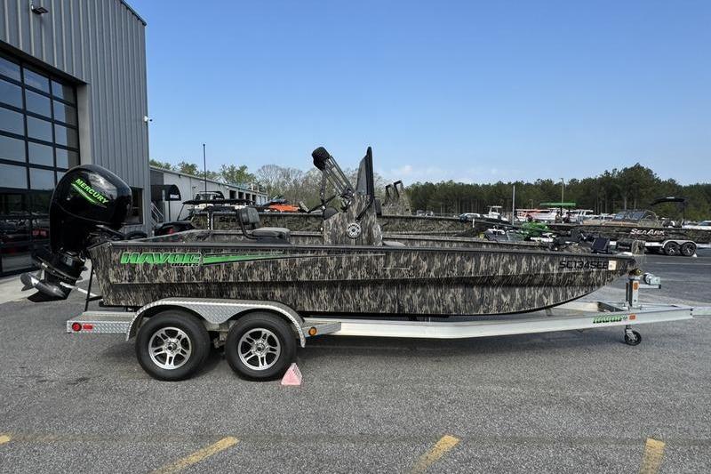 2023 Havoc 1756 MRST boat on trailer, camo design, parked outdoors.