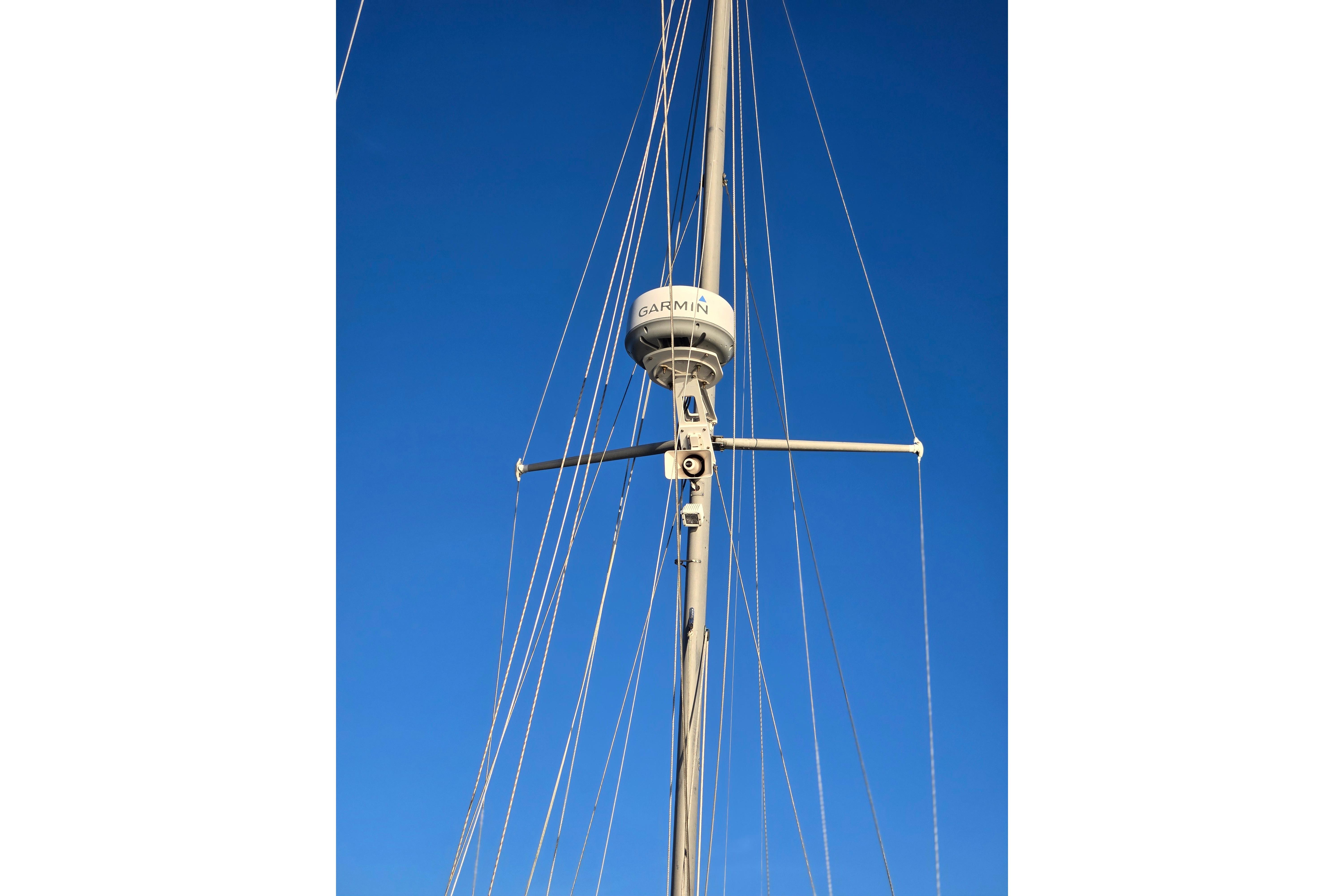 Mast of 1970 Hinckley Bermuda 40 sailboat with Garmin radar against clear blue sky.