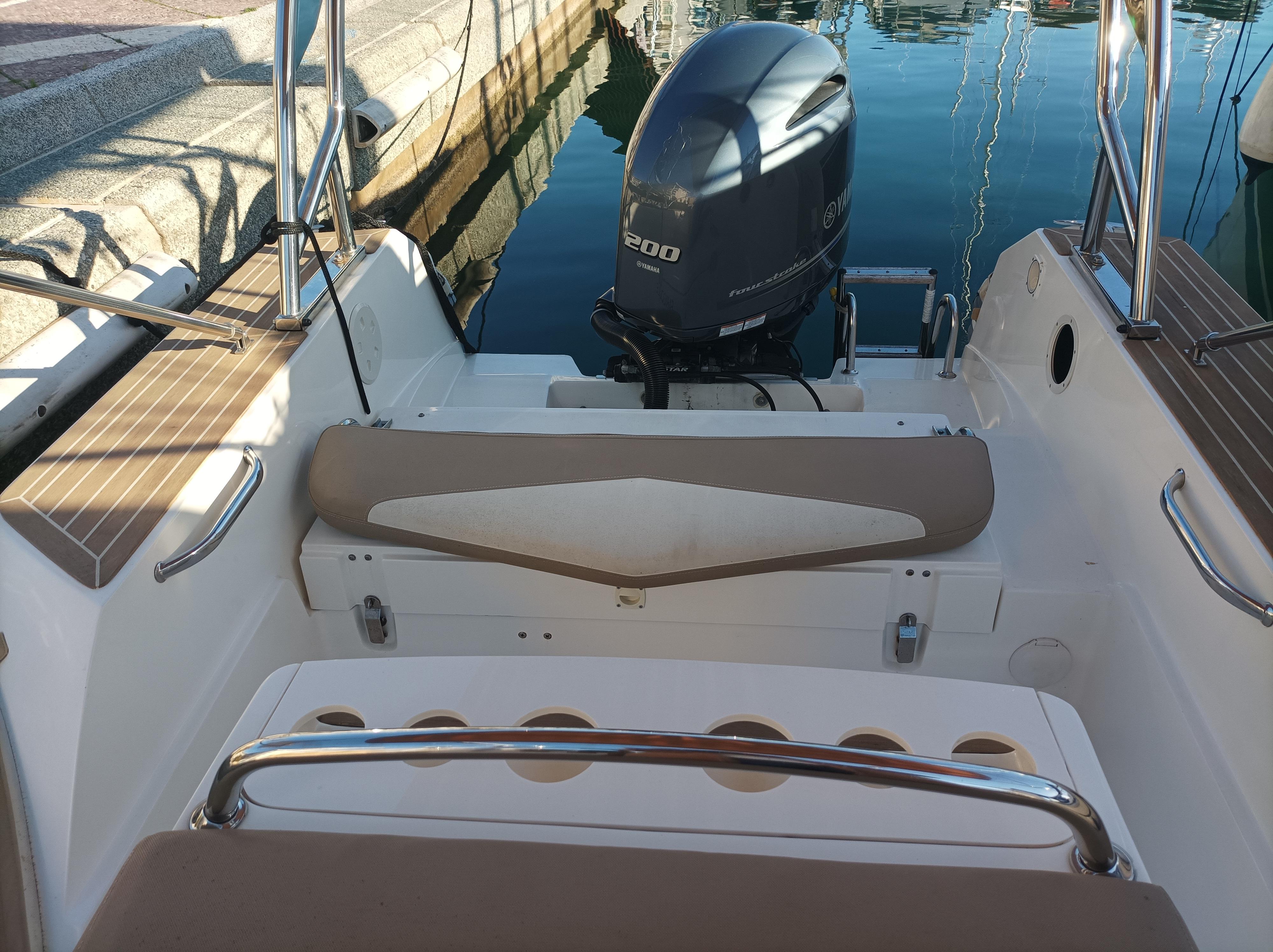 2019 Capelli Tempest 700 Open boat interior with motor, docked at marina.