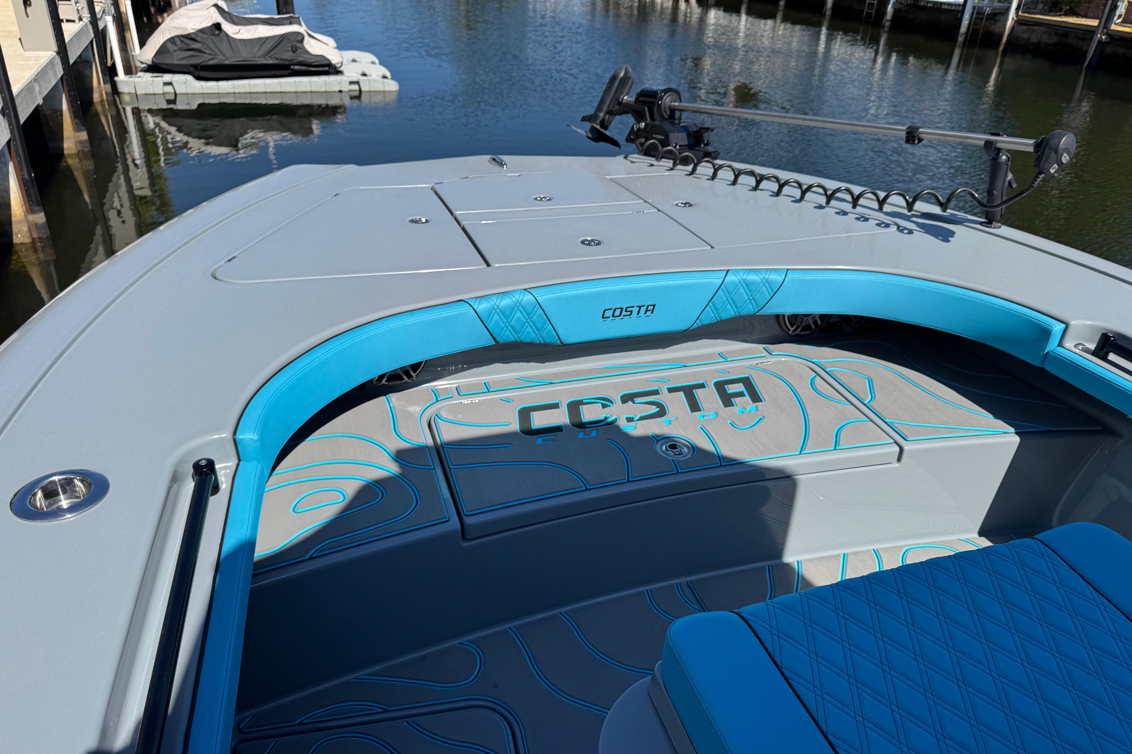 2026 Costa Custom Boats 264 HC, sleek design, blue accents, docked on calm water.