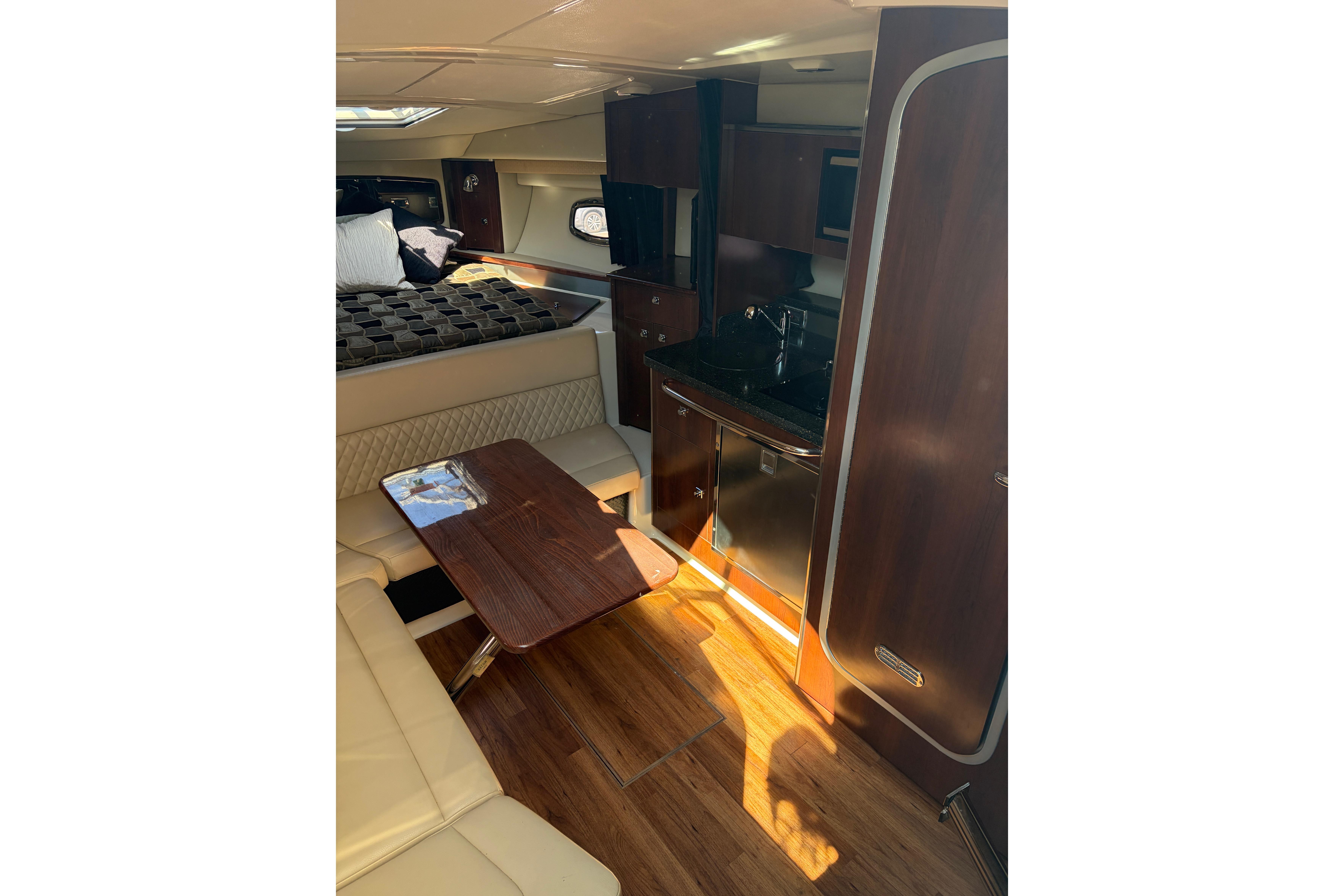 Interior of 2013 Chaparral 310 Signature boat with cozy seating and kitchenette.