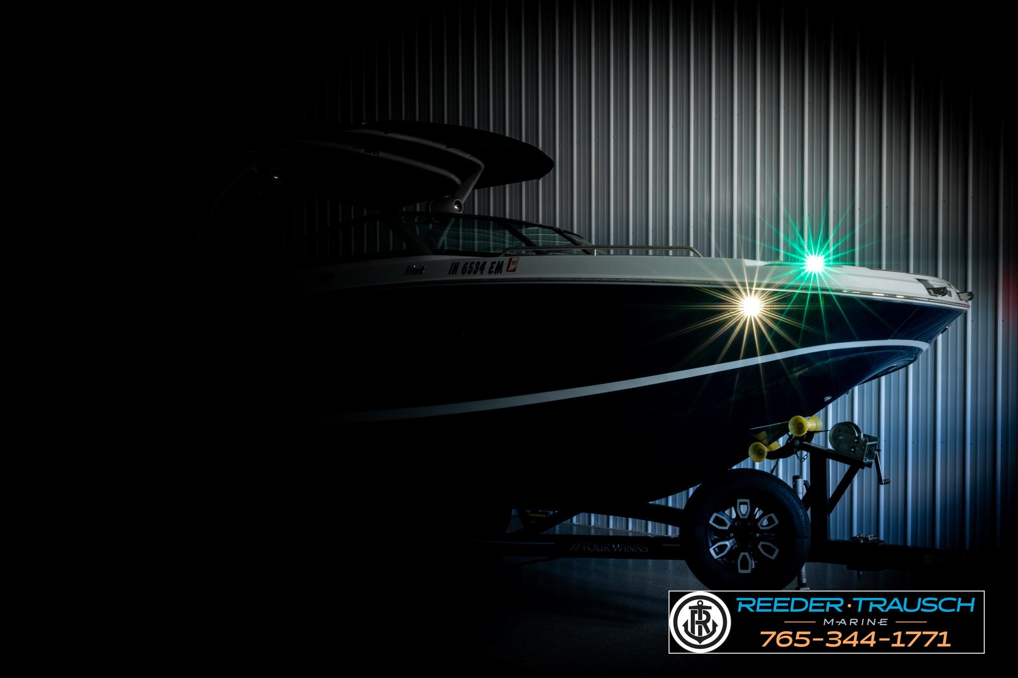 2024 FOURWINNS HD5 Surf boat in dimly lit showroom, side view.