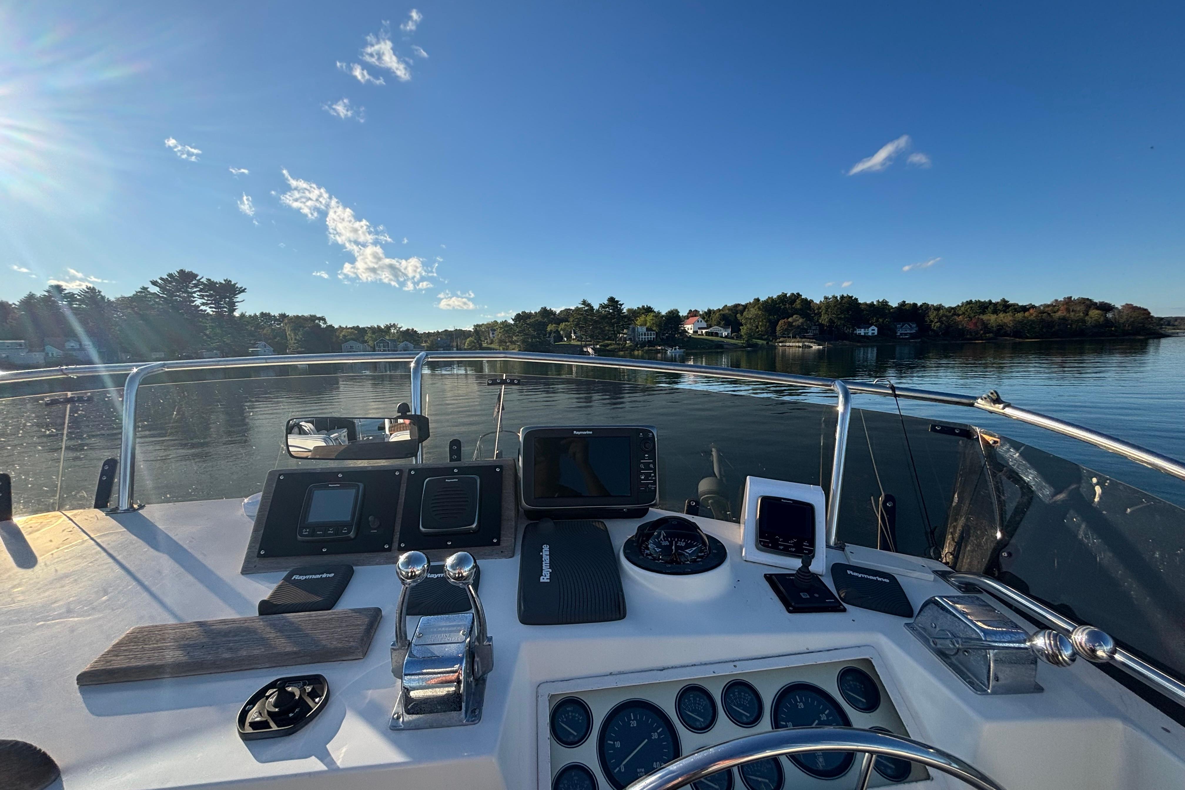 Helm of 1989 Grand Banks 46 Classic yacht with navigational instruments, overlooking calm waters.