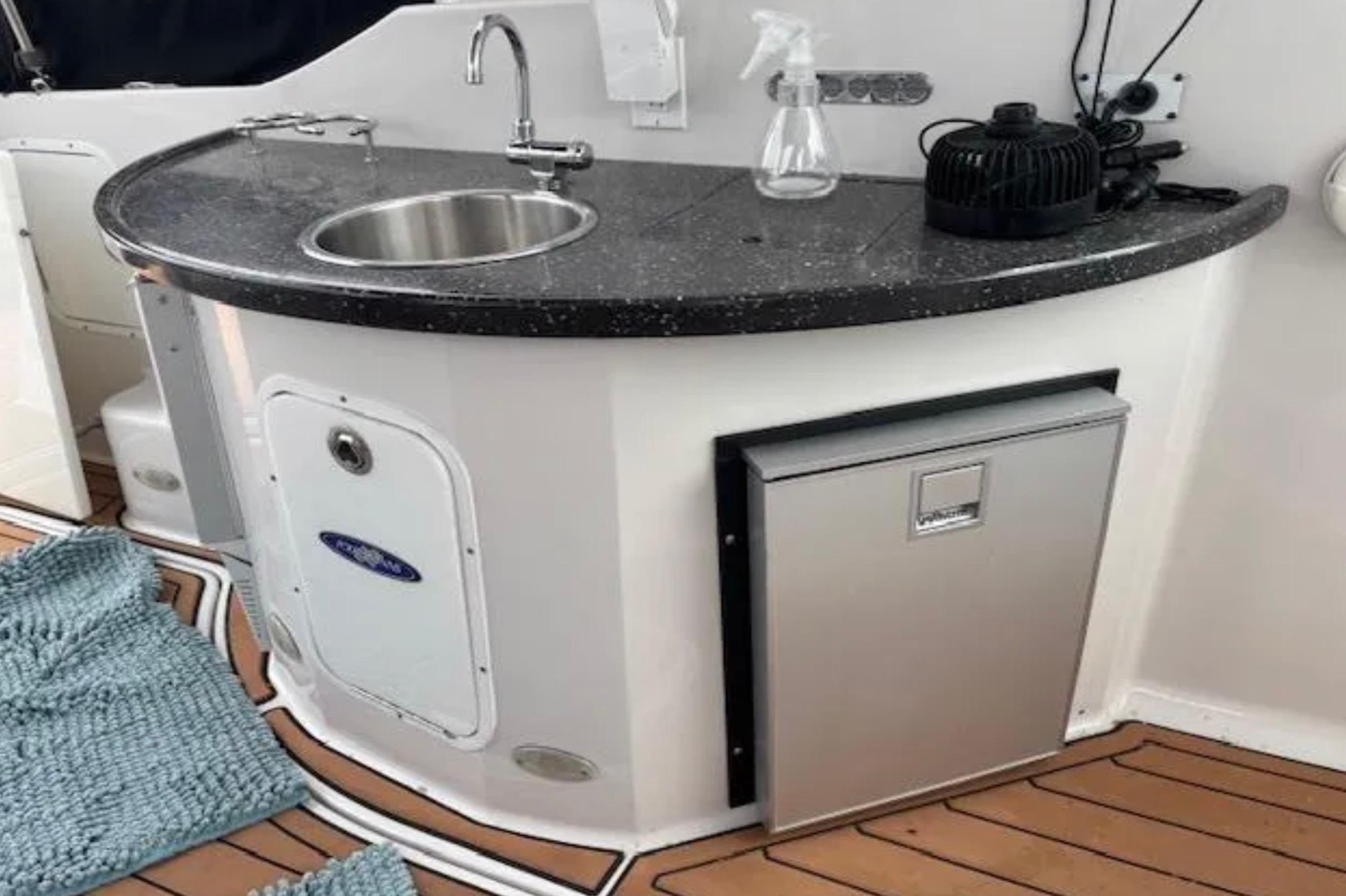 2007 Four Winns 378 Vista yacht kitchenette with sink, countertop, and mini fridge.