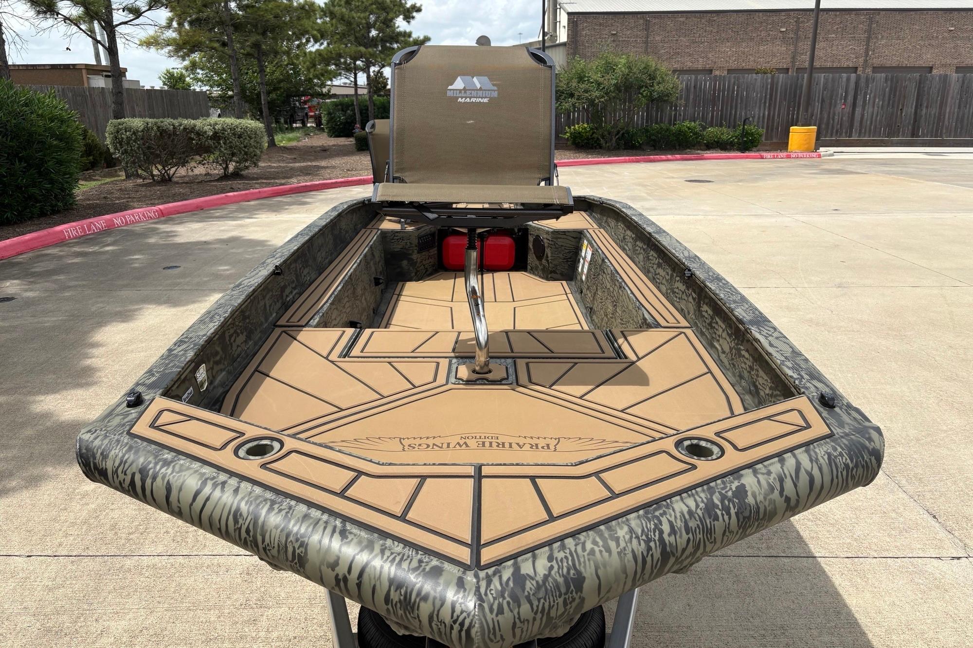 2026 Tracker Grizzly 1650 T Prairie Wings Edition boat with camouflage design in a parking area.