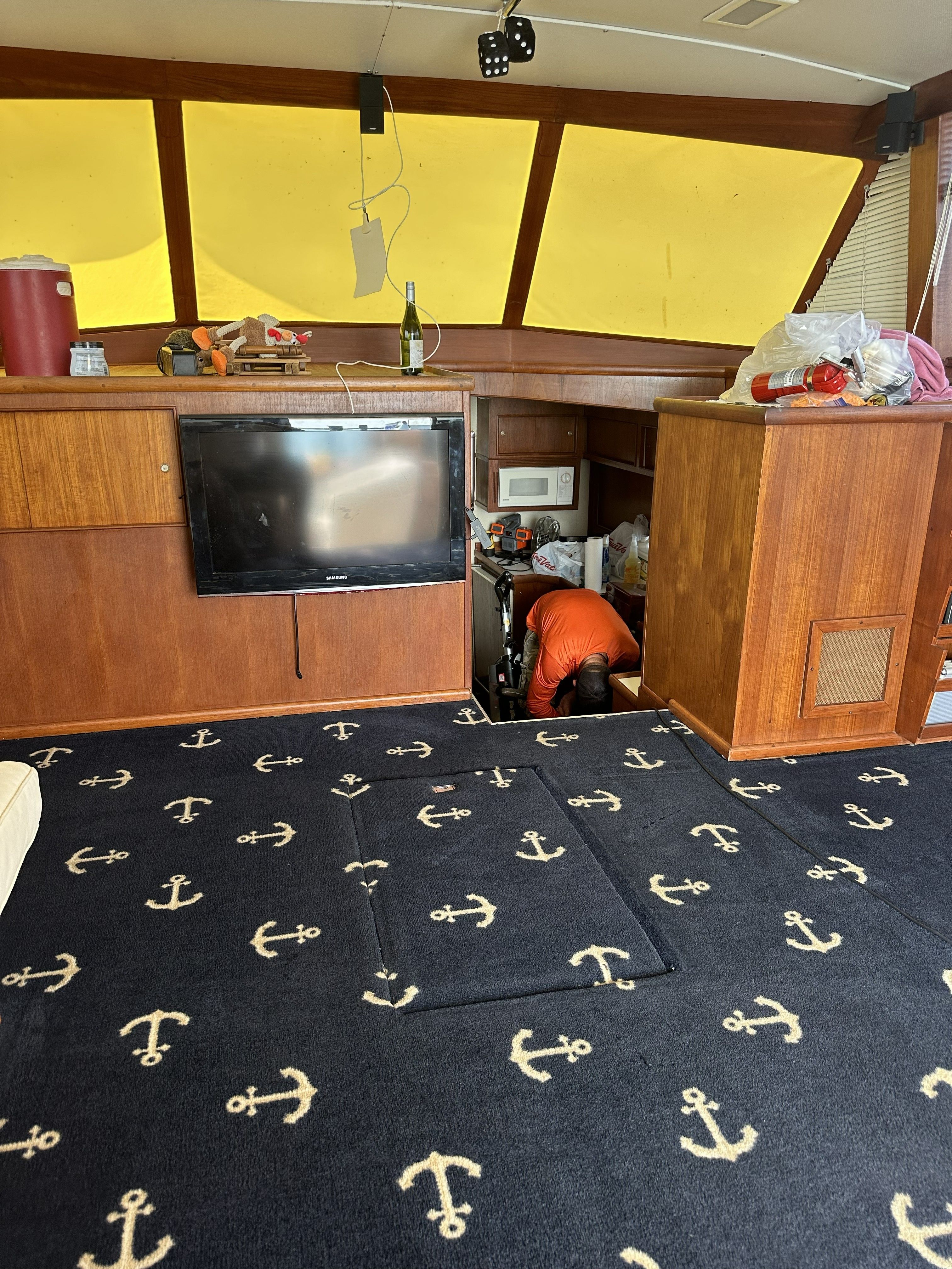 Interior of a 1979 Chris-Craft 45 TF with anchor-patterned carpet and a television.