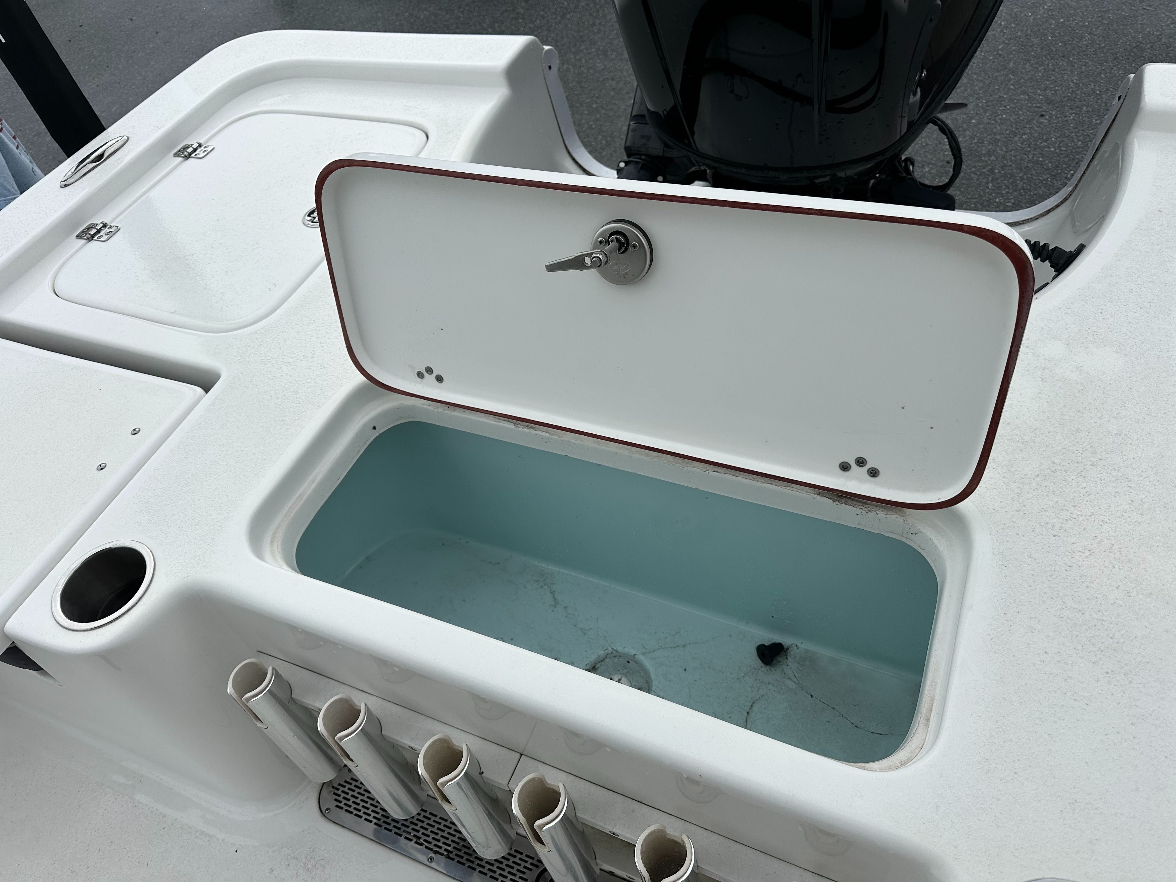 The image shows the stern of a Sea Pro 230 DLX boat with an open storage compartment.