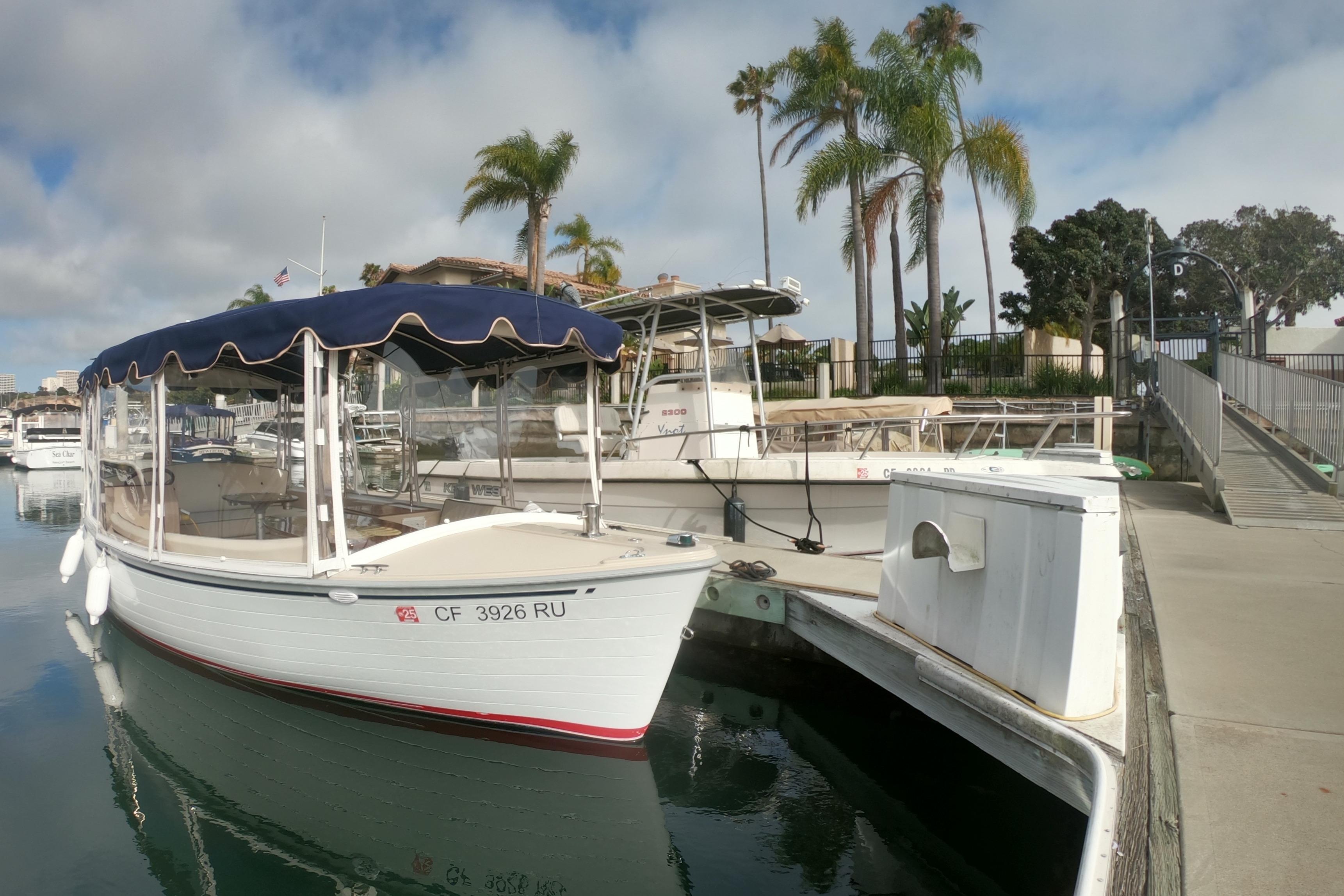 2008 Duffy Snug Harbor 18 boat docked at marina with palm trees in background.