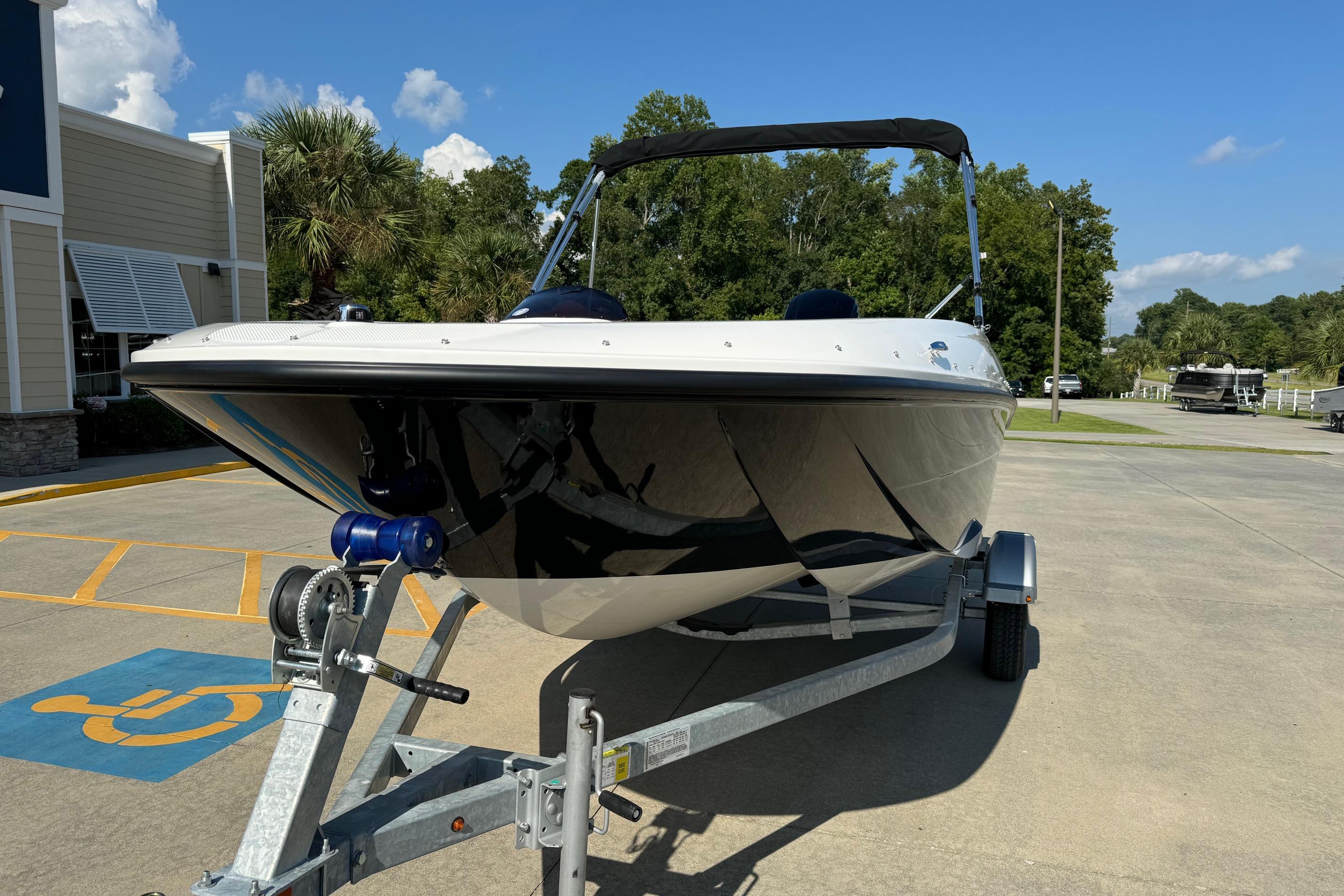 2025 Bayliner Element E16 boat on trailer, parked outdoors under clear blue sky.