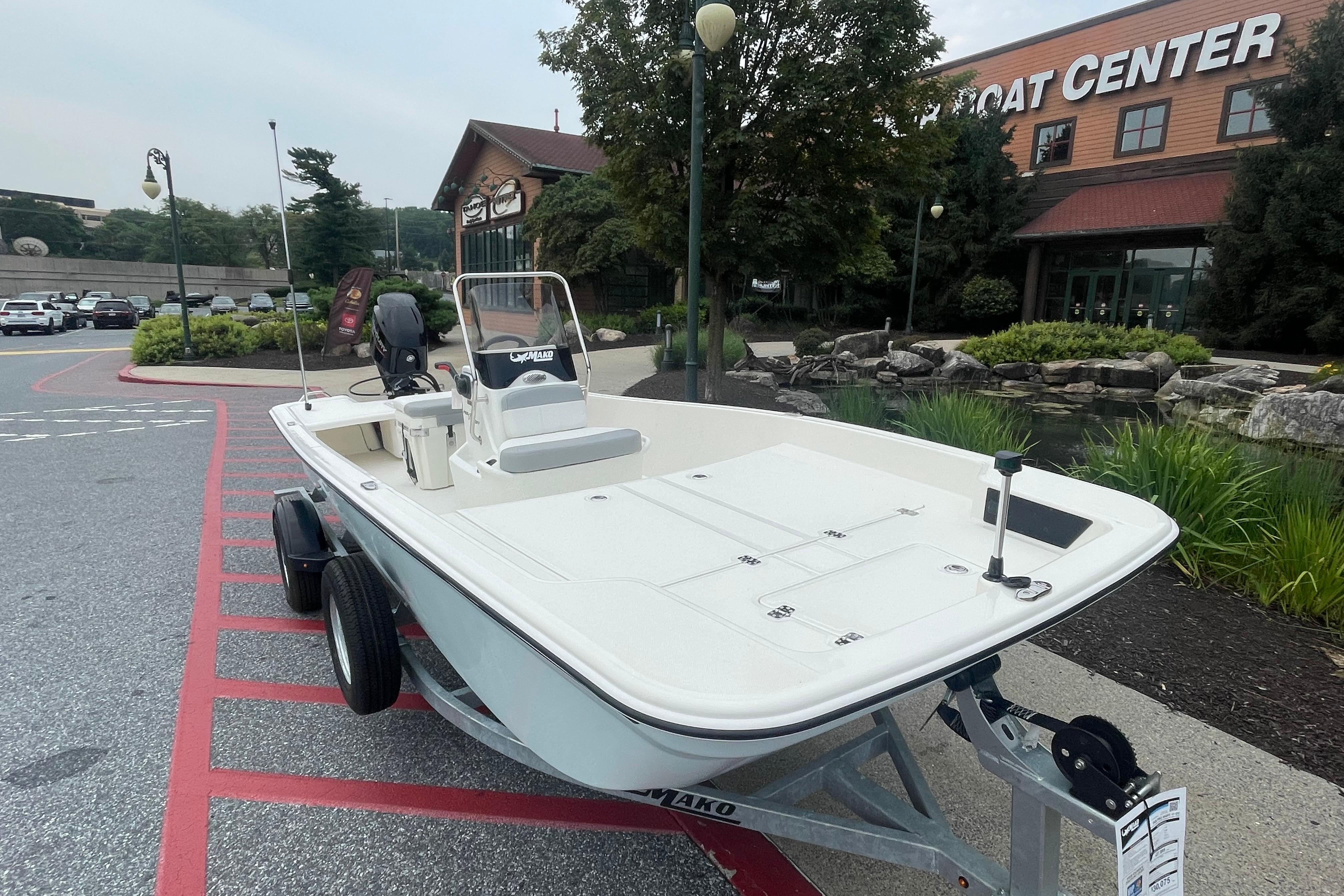 2026 Mako Pro Skiff 17 CC boat on trailer outside a boat center.