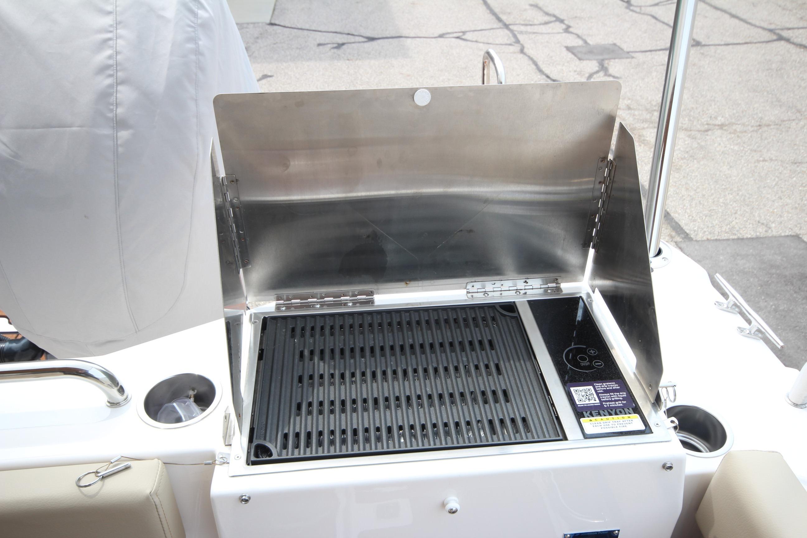 Outdoor grill on 2025 Ranger Tugs R-25 boat, featuring stainless steel design and protective cover.