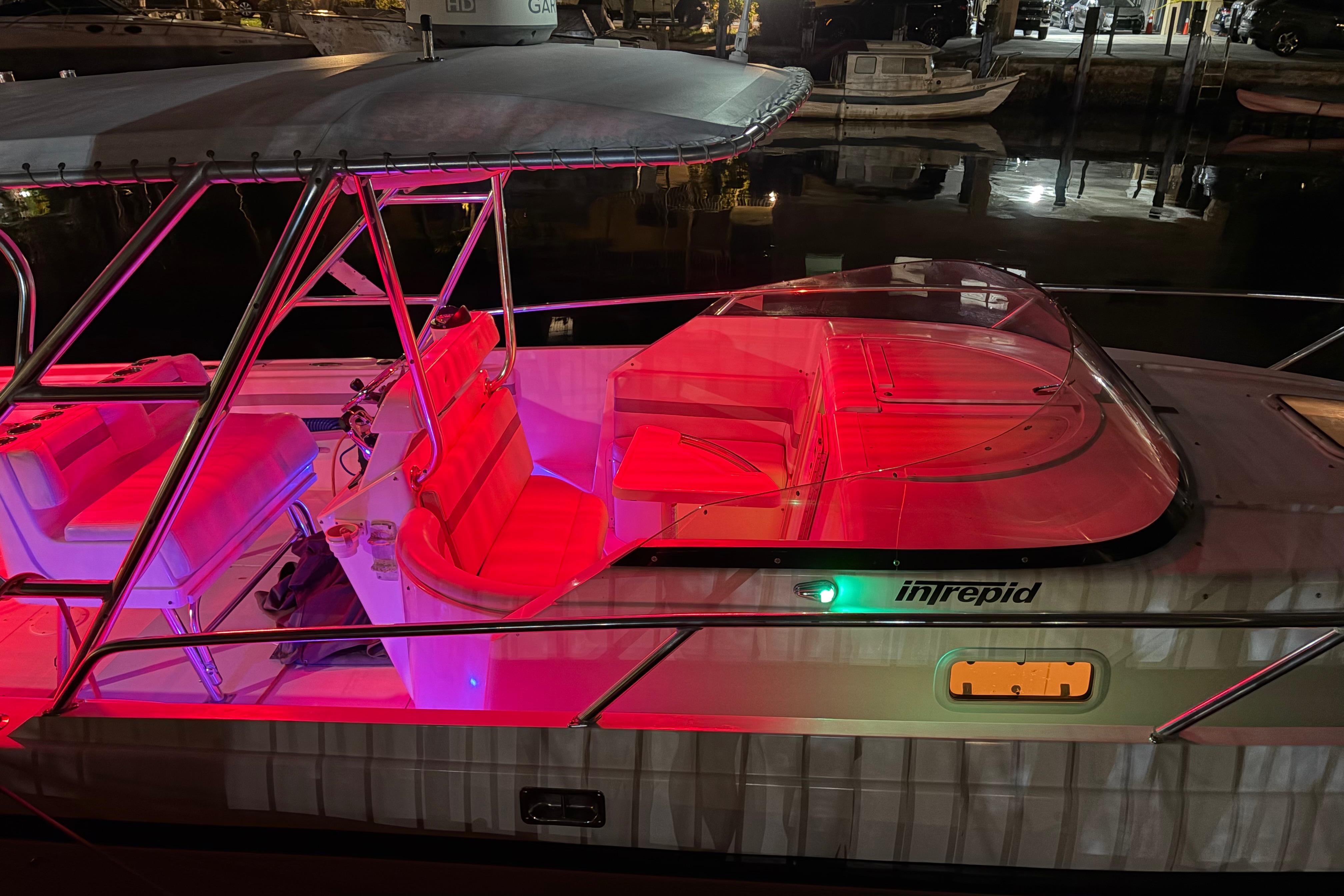 1998 Intrepid 339 Walkaround boat illuminated with red lights at night.