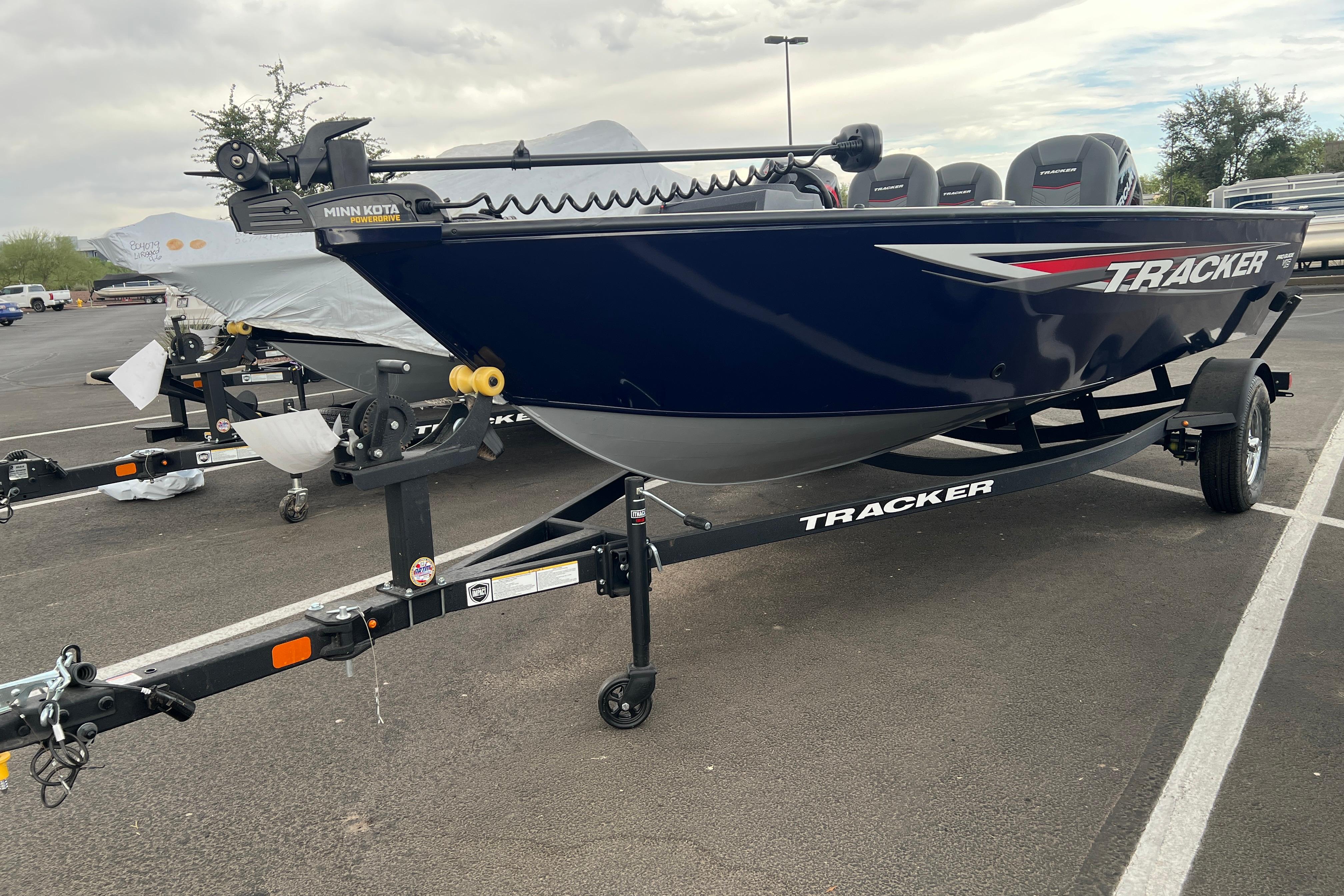 2026 Tracker Pro Guide V-16 SC boat on trailer in parking lot.