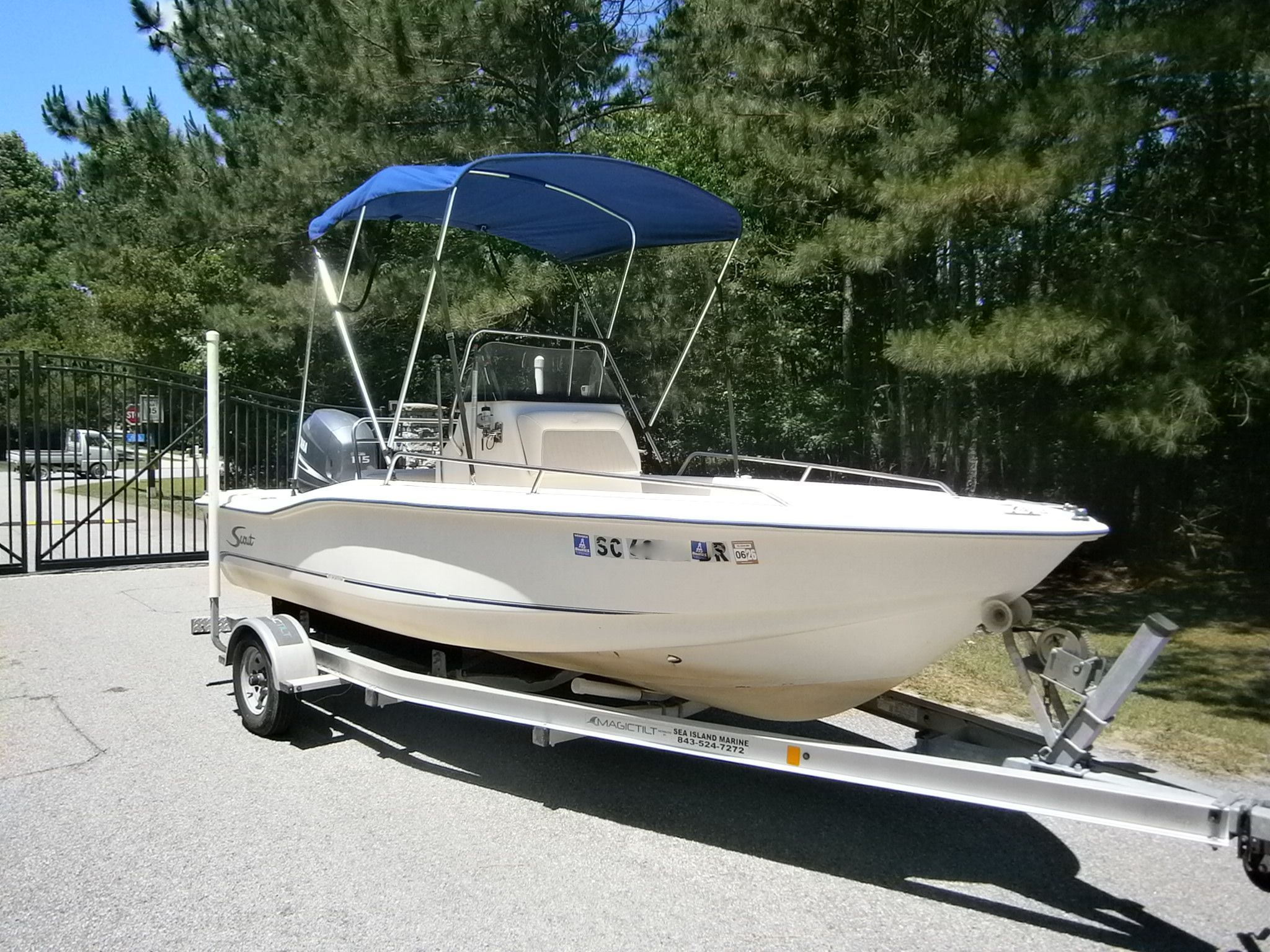2004 Scout 175 Sportfish boat on trailer outdoors.
