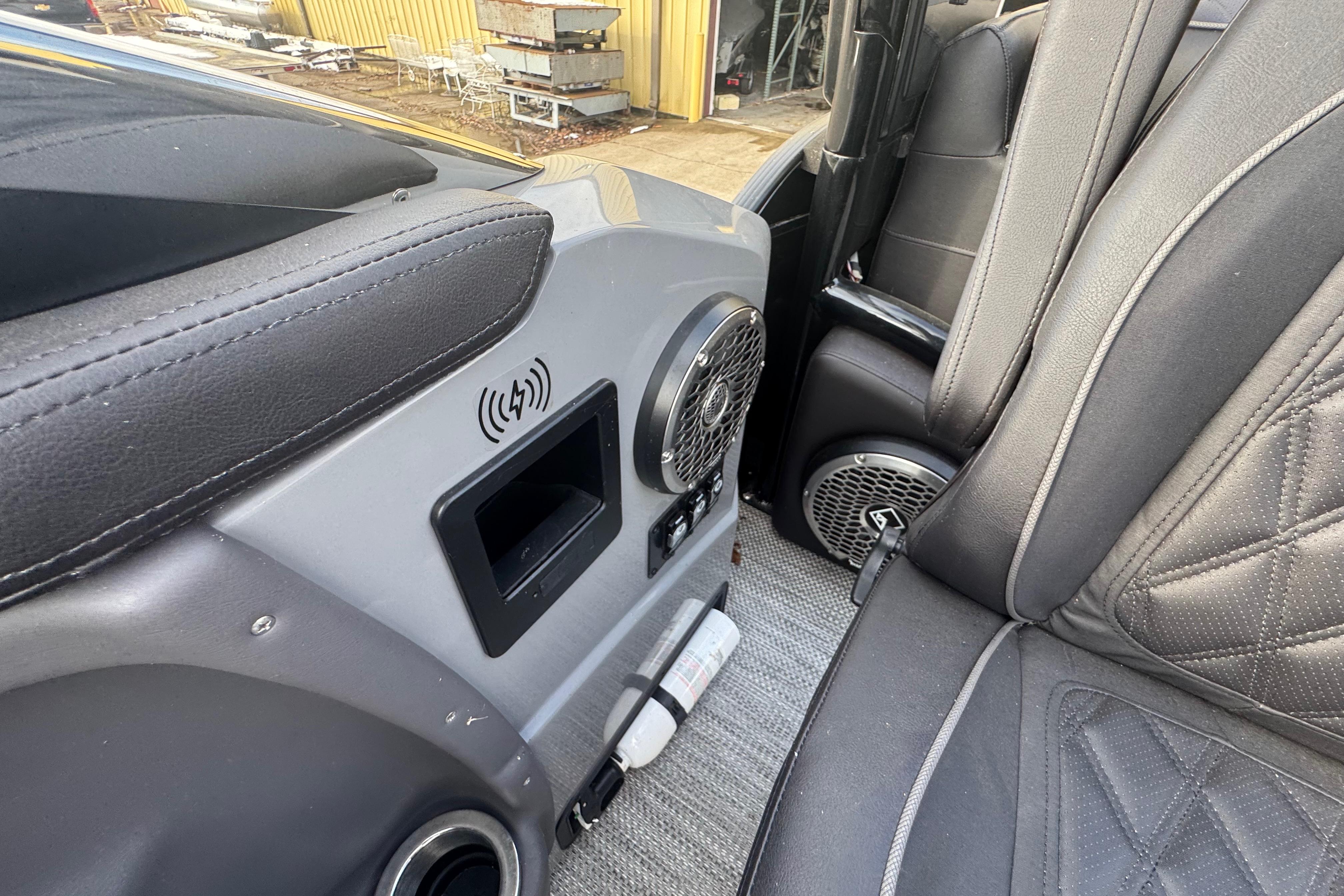 Interior of 2023 Bennington 30 QXFBAX2 boat with speaker and wireless charging pad.