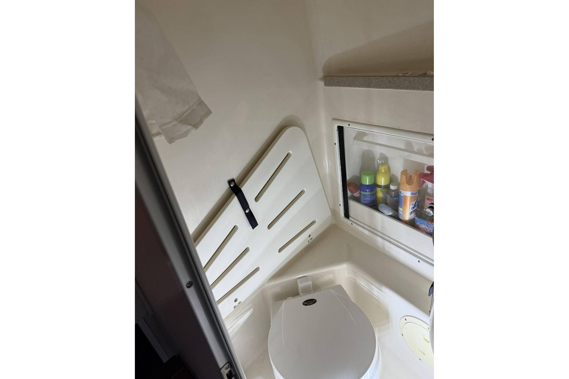 Interior of 2000 Pursuit 3070 Offshore Center Console boat, featuring a compact bathroom area.