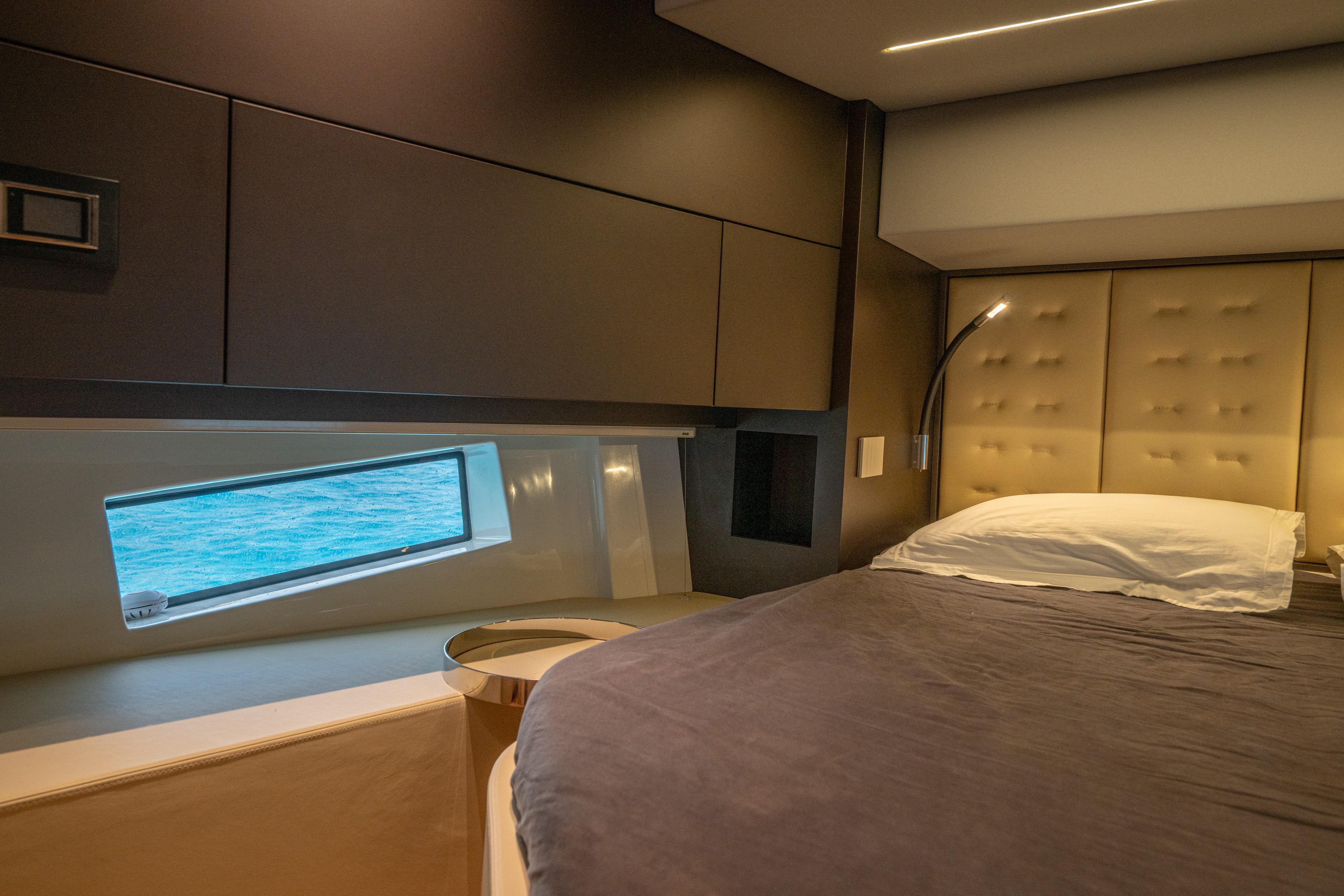 Luxurious 2024 SACS Rebel 55 yacht bedroom with ocean view window.